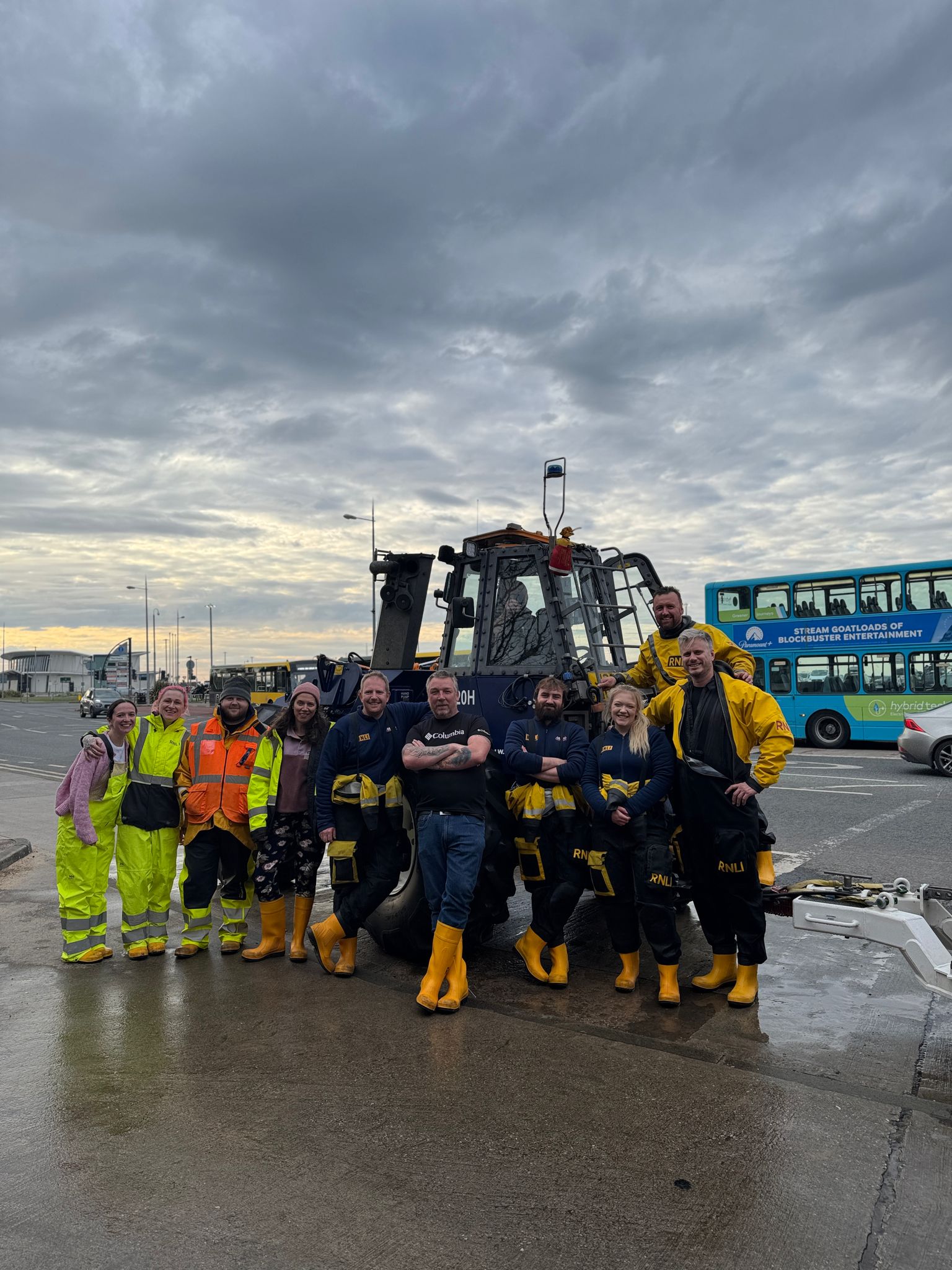 A group of New Brighton's volunteer crew stand posed proudly in front of the tractor.
