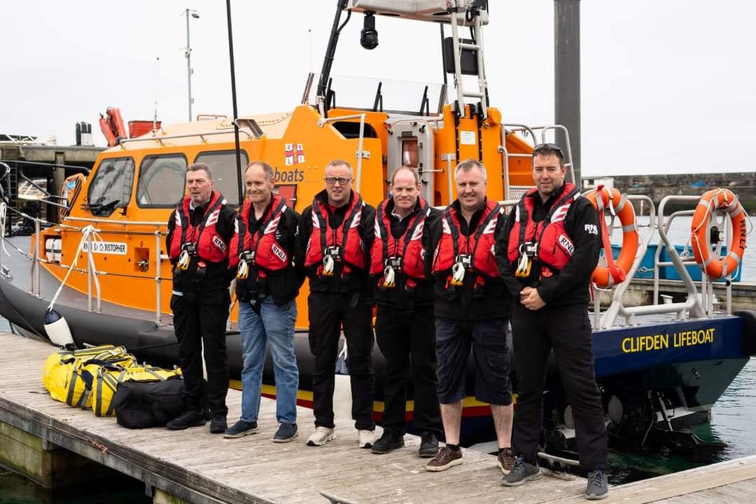 Six crew in lifejackets lined up on a pontoon with the Shannon class ALB in the background