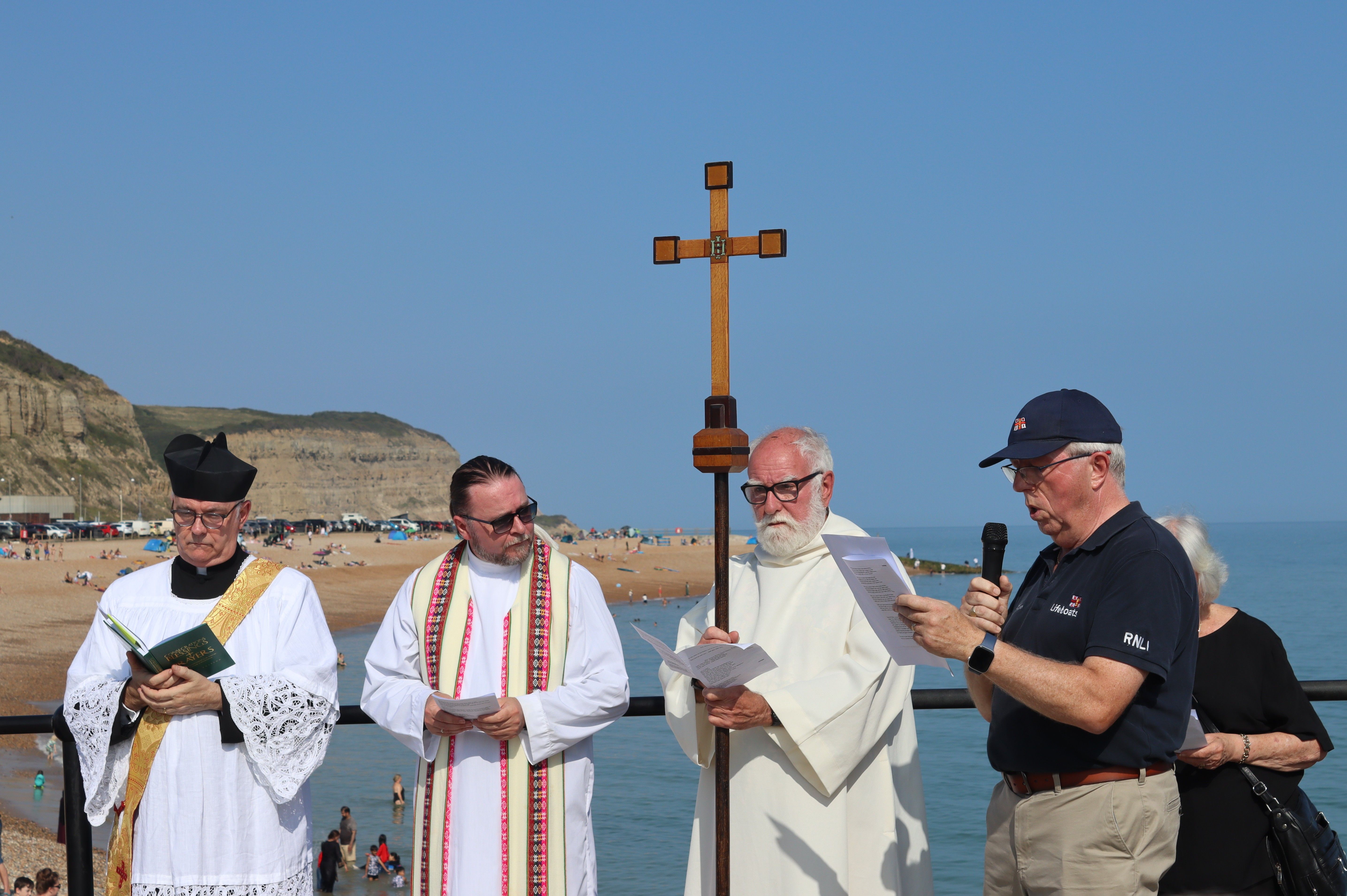 RNLI Lifeboat Management Group chair Paul Freathy reads the lesson as the celebrants look on