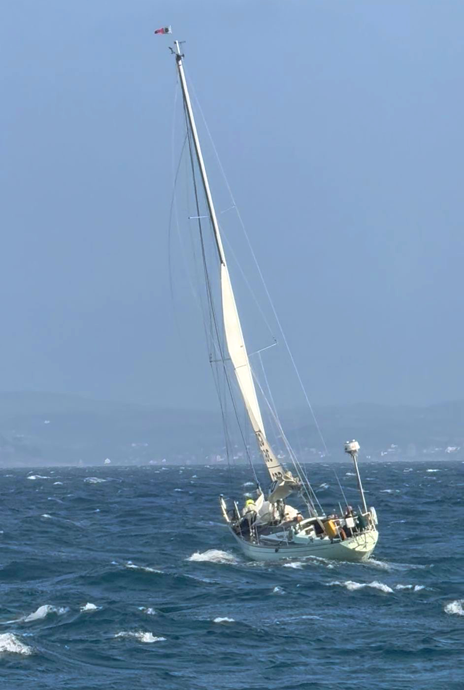 Picture shows a yacht under limited sail