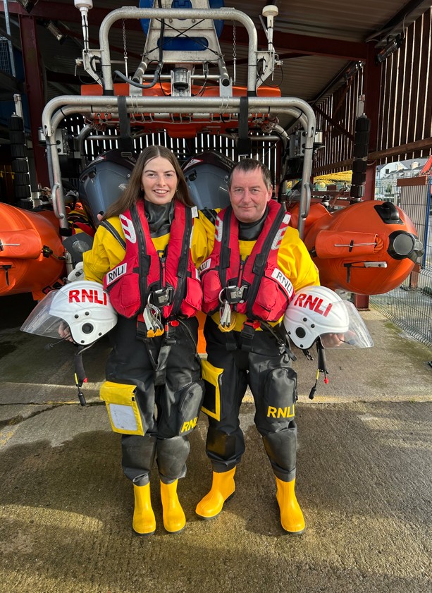Father and daughter Aodh and Muireann O’Donnell from Union Hall RNLI in lifeboat kit standing in front of lifeboat