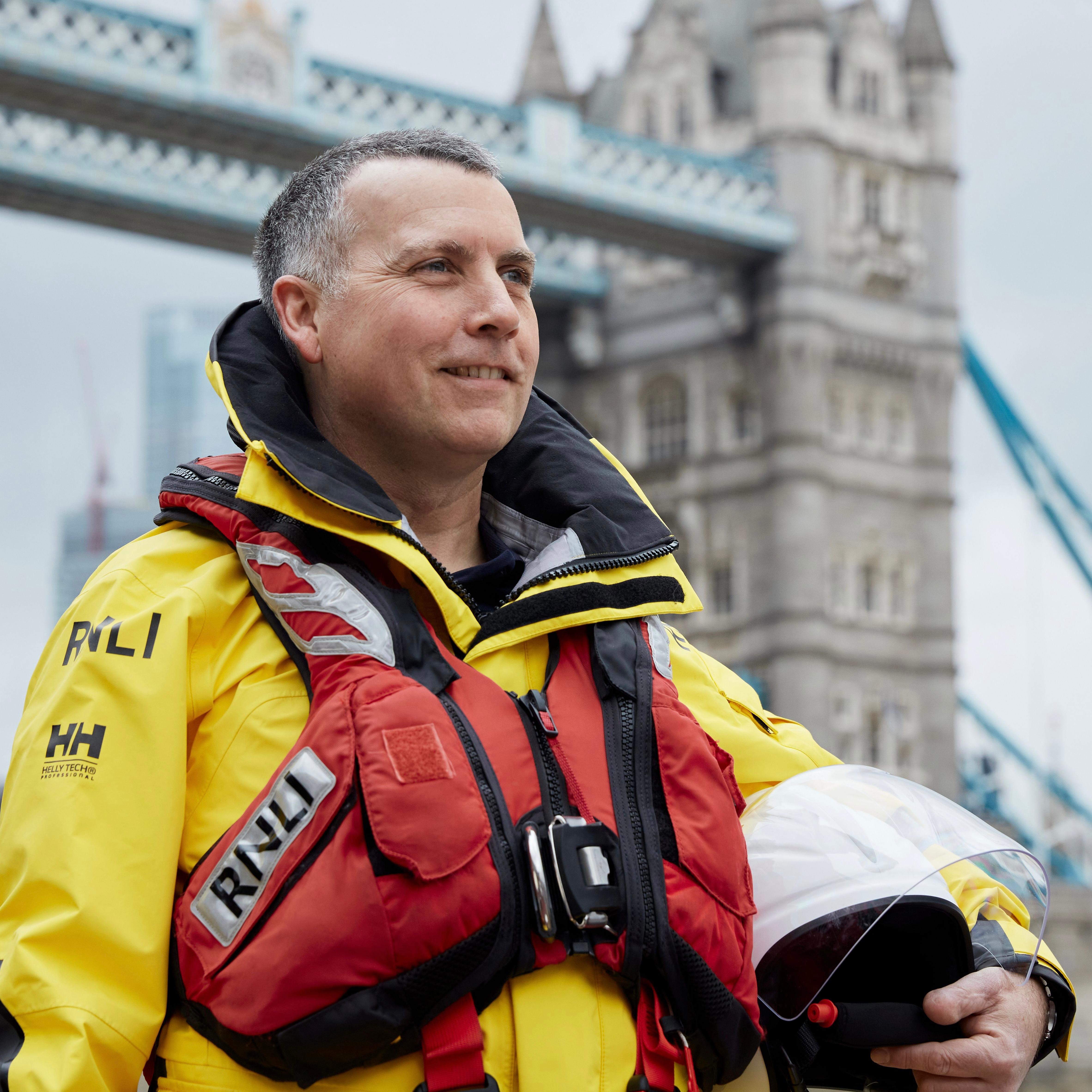 Colin McCarthy standing in full kit in front of Tower Bridge
