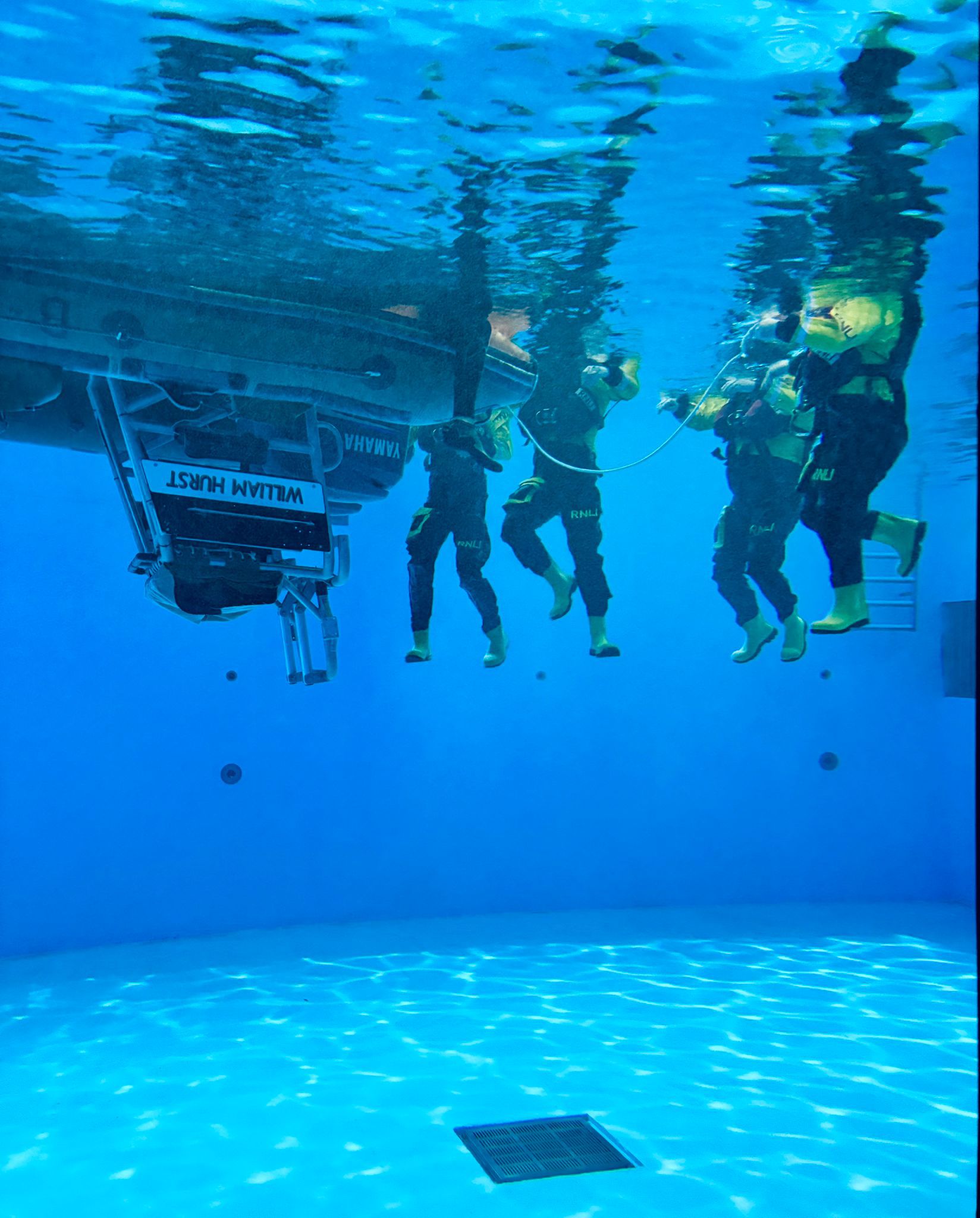 Harry with crew mate Emma at the RNLI training College in Poole, on their Crew Emergency Procedures Course. This image is in the training pool where they capsize a lifeboat, the crew need to learn how to right the lifeboat and get back in.
