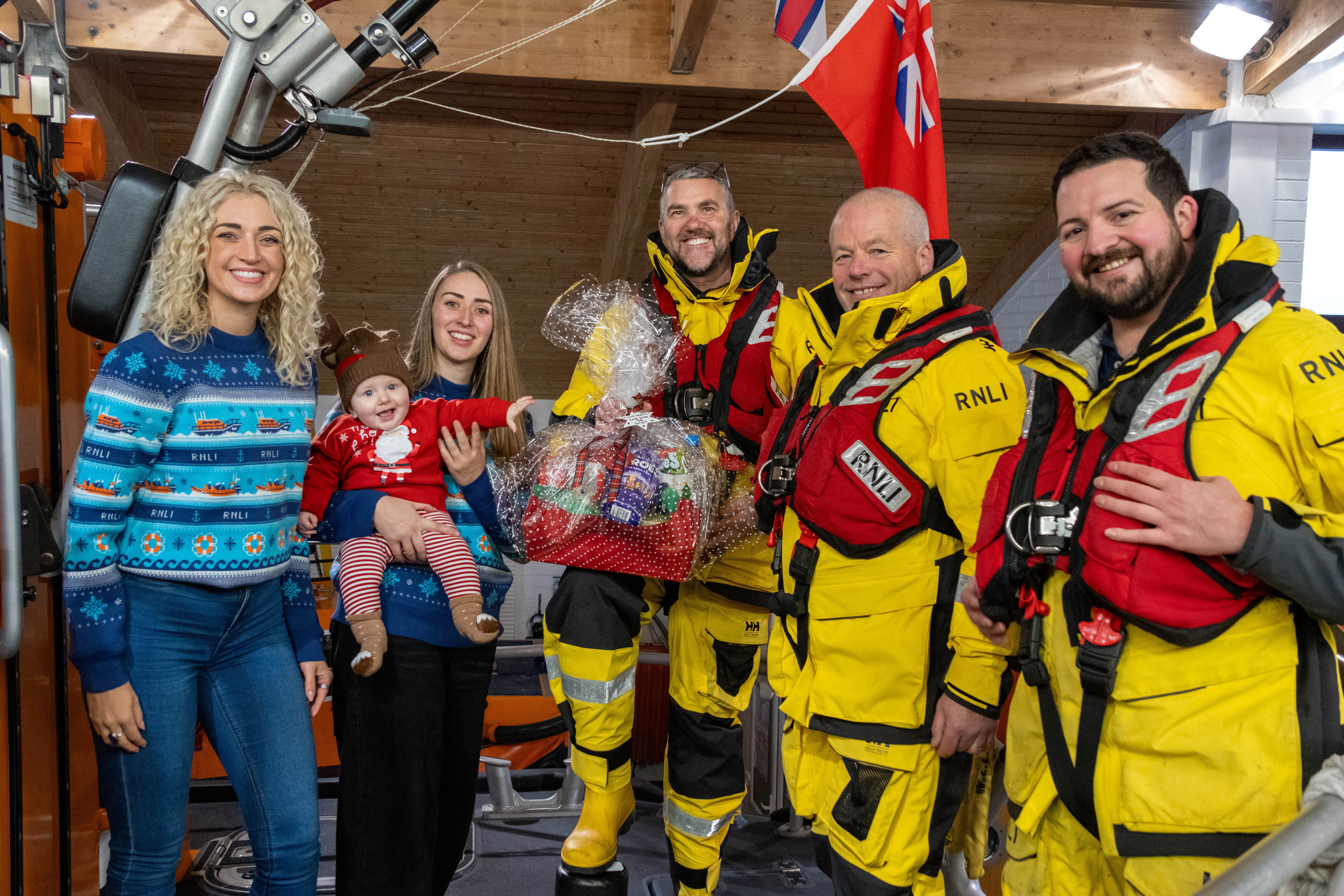 Megan, Brogan and baby Jackson bring gifts to the Hoylake RNLI crew 
