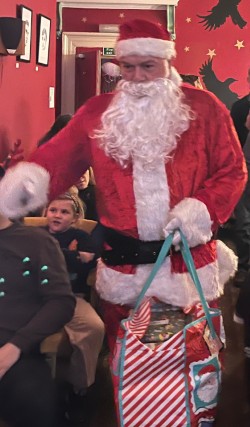Volunteer crew Mick arrived as Santa to surprise the families of the volunteer lifeboat crew. The image shows Santa entering the cinema where the event took place.