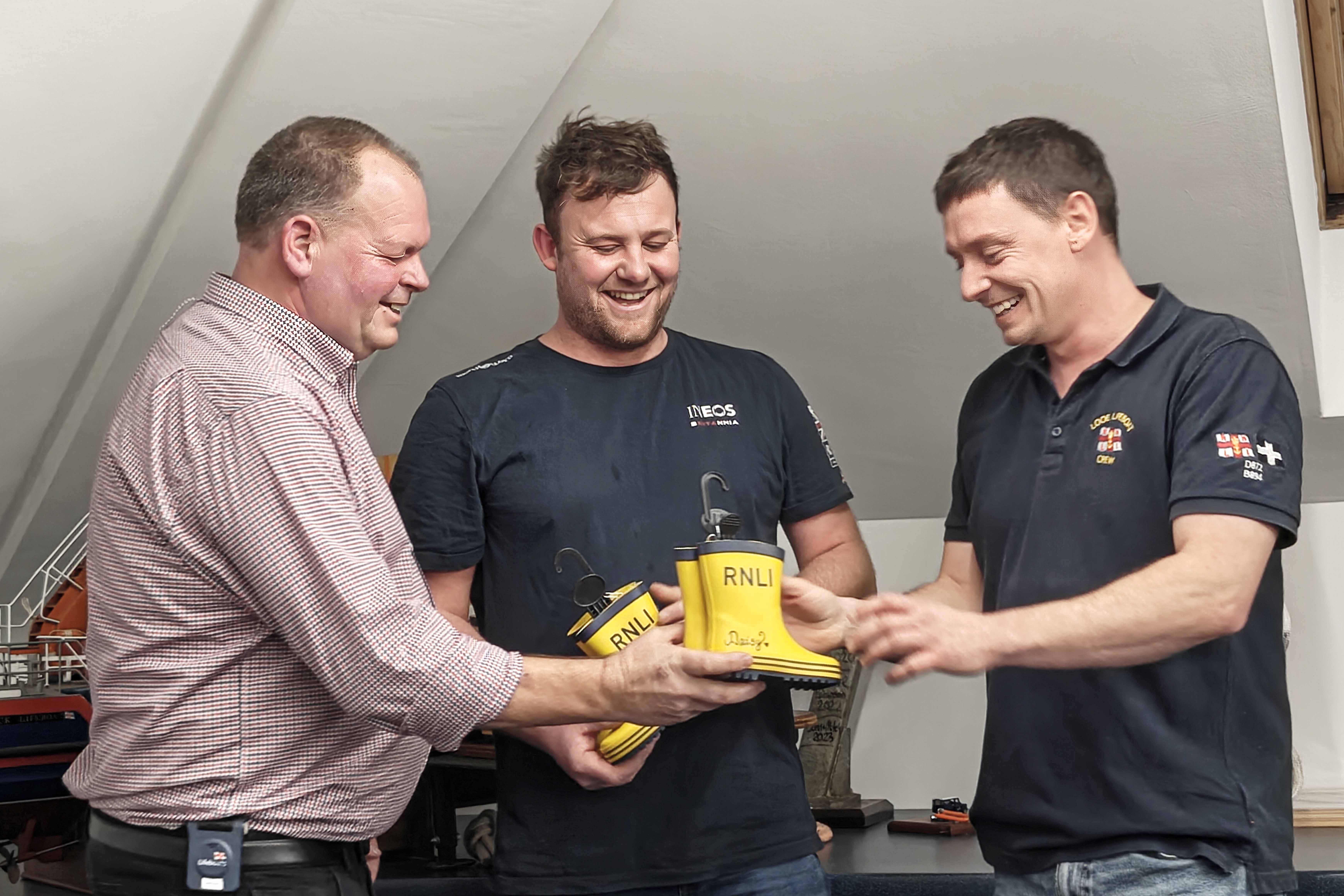 Clive presenting yellow wellies to Jack and Tom
