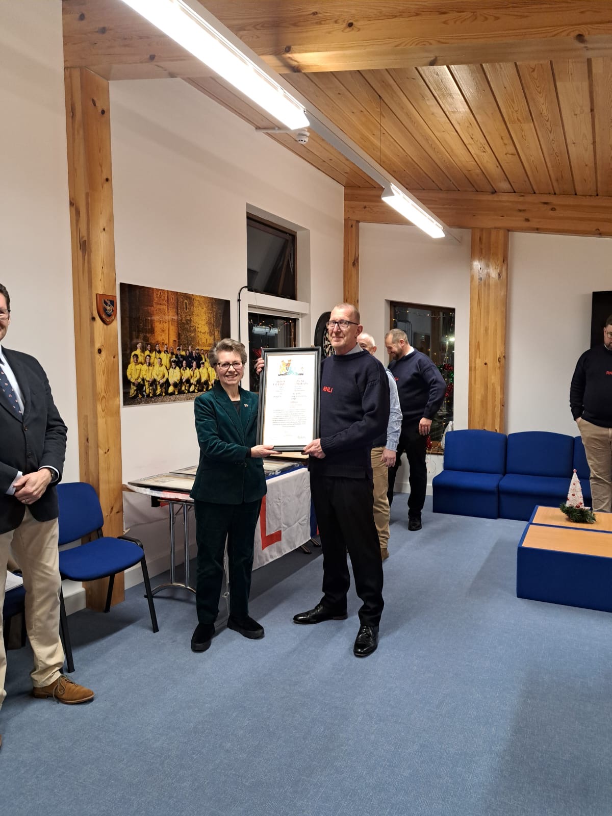 Member's of Dover RNLI receiving Vellum awards posing for photographs in crew room