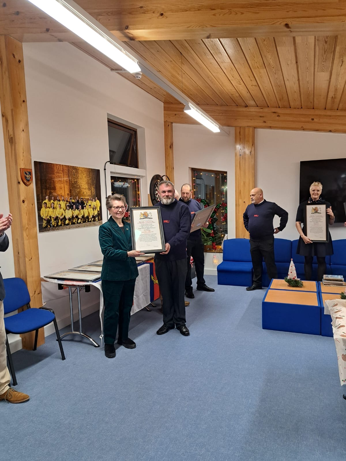 Member's of Dover RNLI receiving Vellum awards posing for photographs in crew room