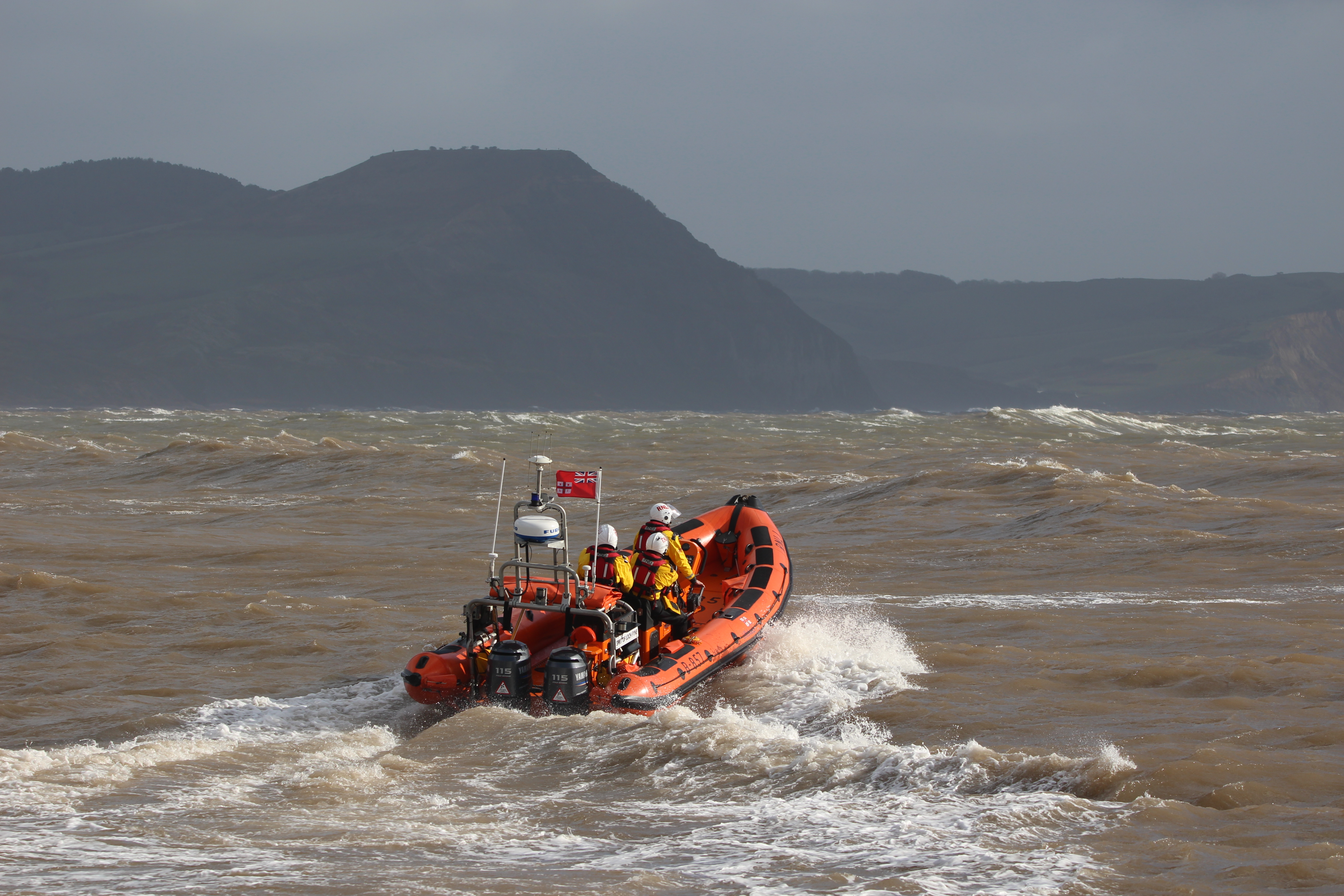 orange boat in rough sea