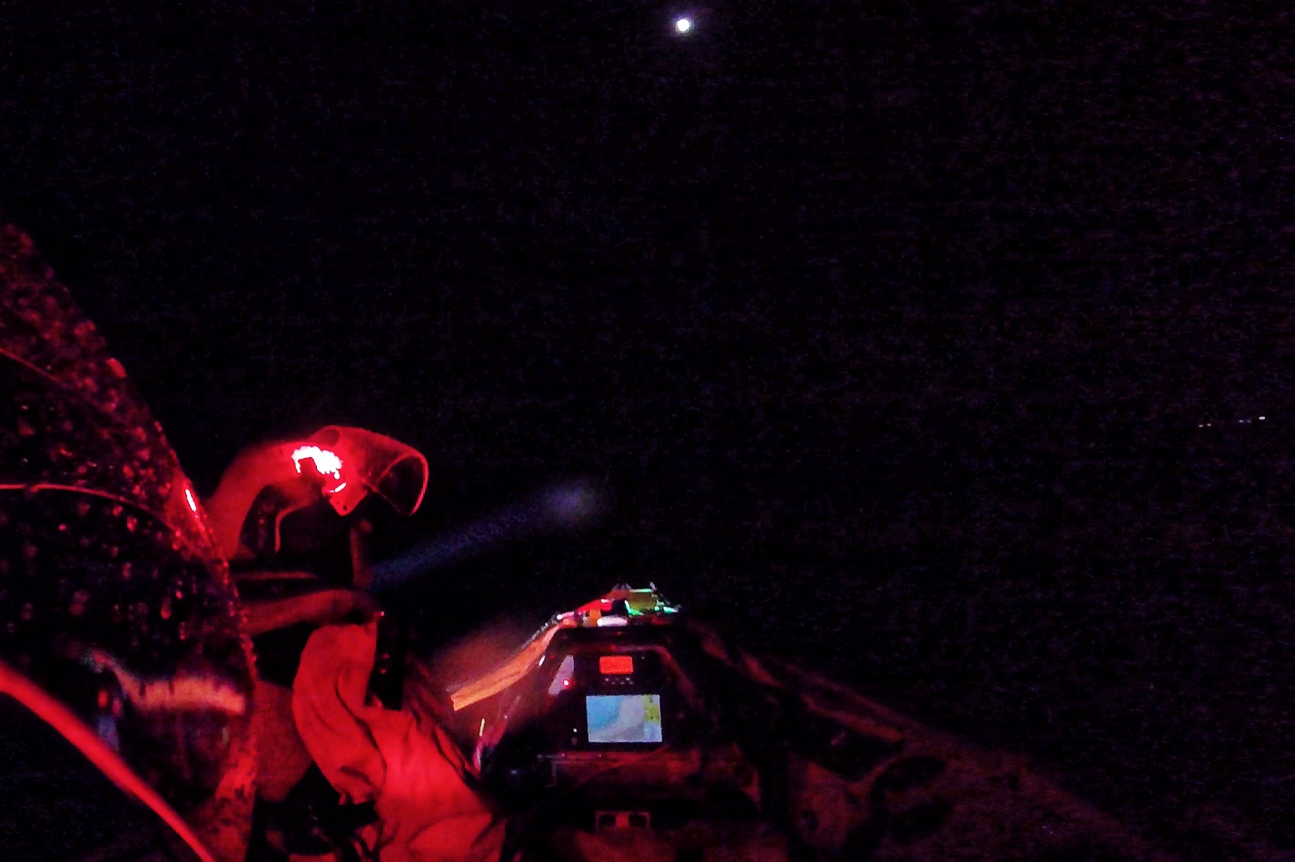 Crew member using a search light to illuminate the shoreline