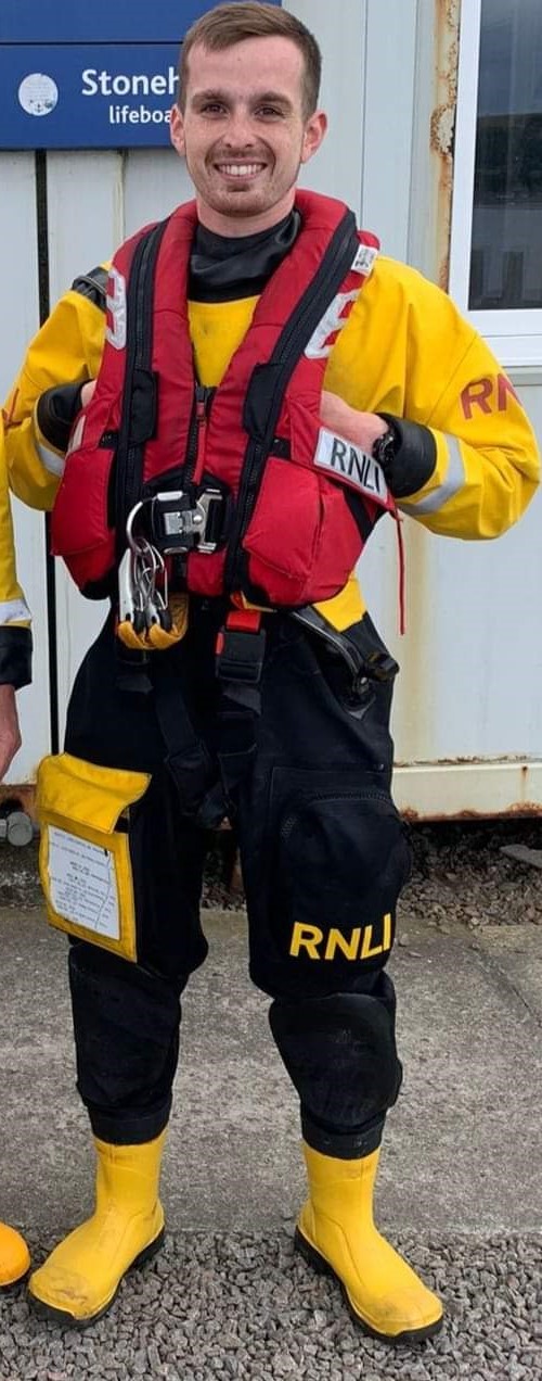 New helm Jamie Longfield in his RNLI yellow and black dry suit, with red RNLI life jacket