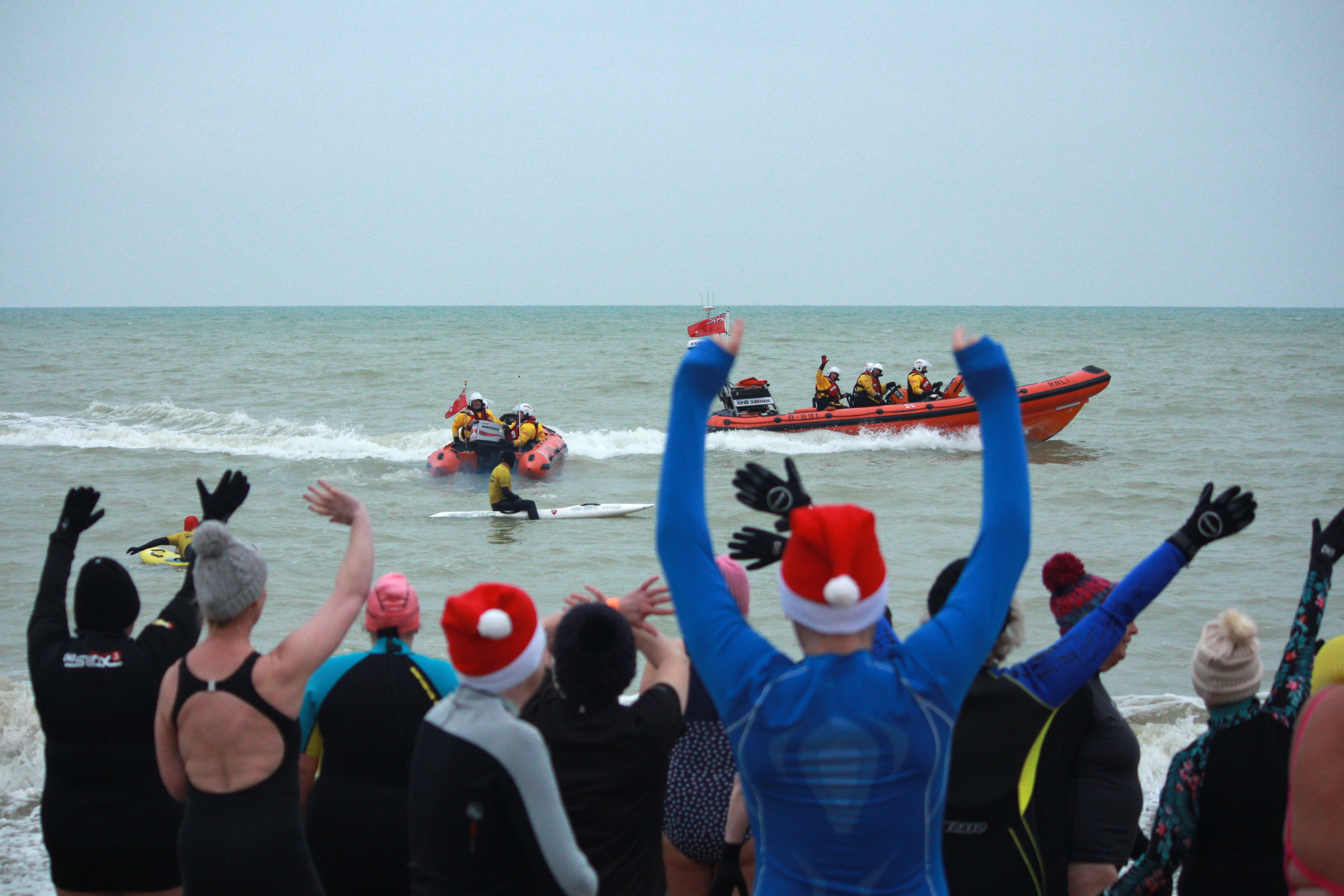 Participants wave at Littlehampton Lifeboats as the dippers prepare to enter the water.
