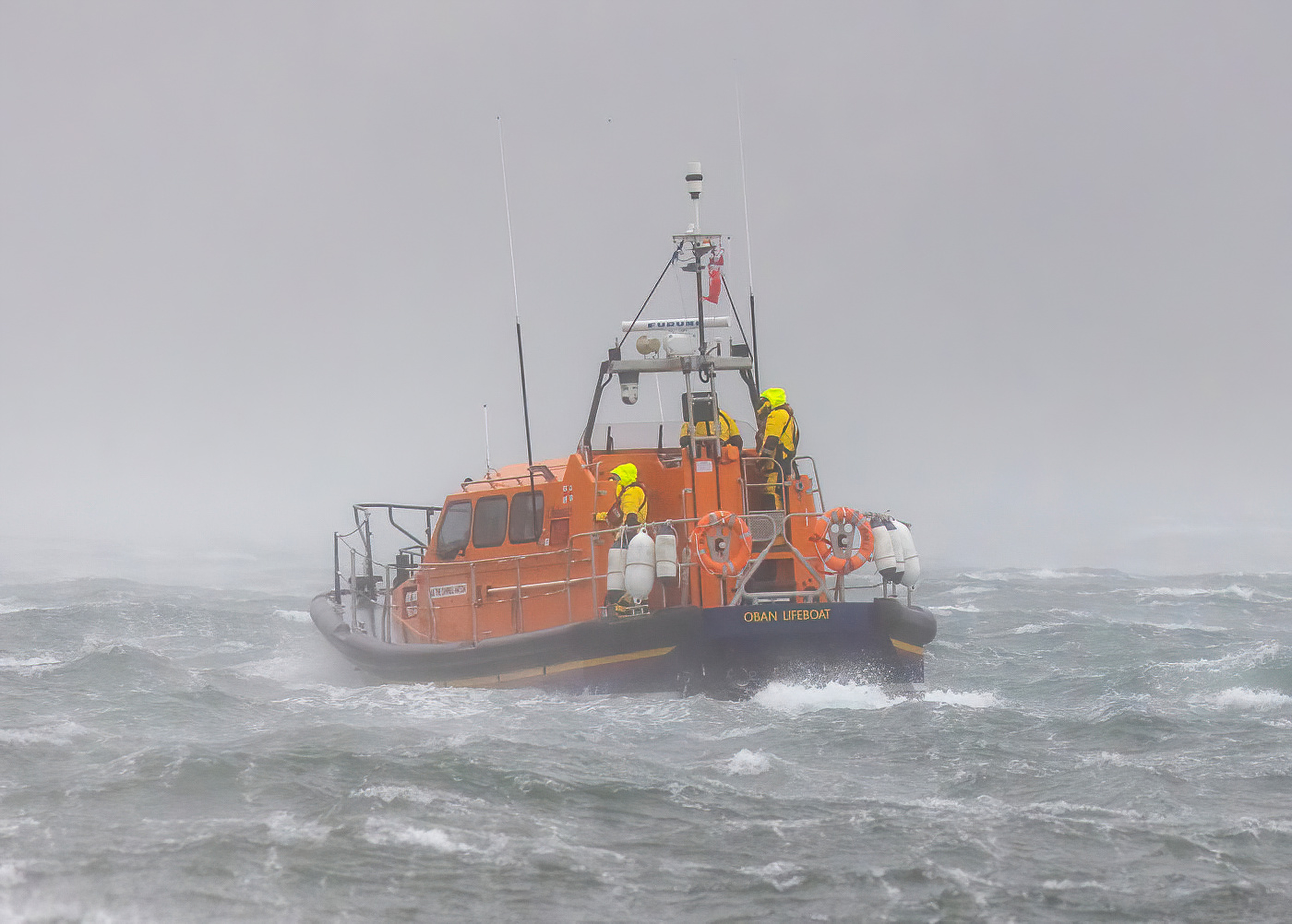 An image of the lifeboat taken from Oban's North Pier the spray forming a mist around the vessel.