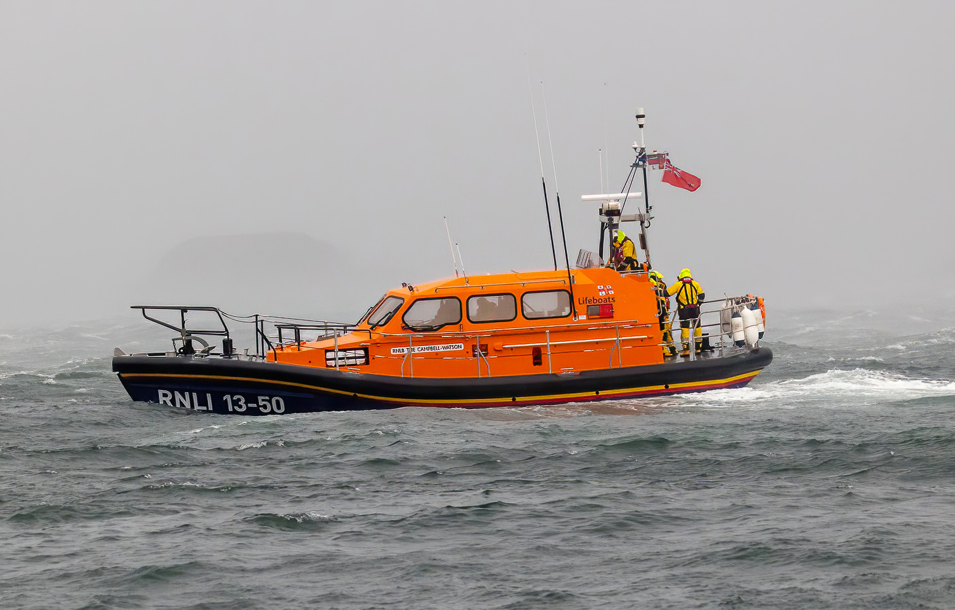 An image of the lifeboat taken from Oban's North Pier showing the heavy seas around her and her bow deep into a wave
