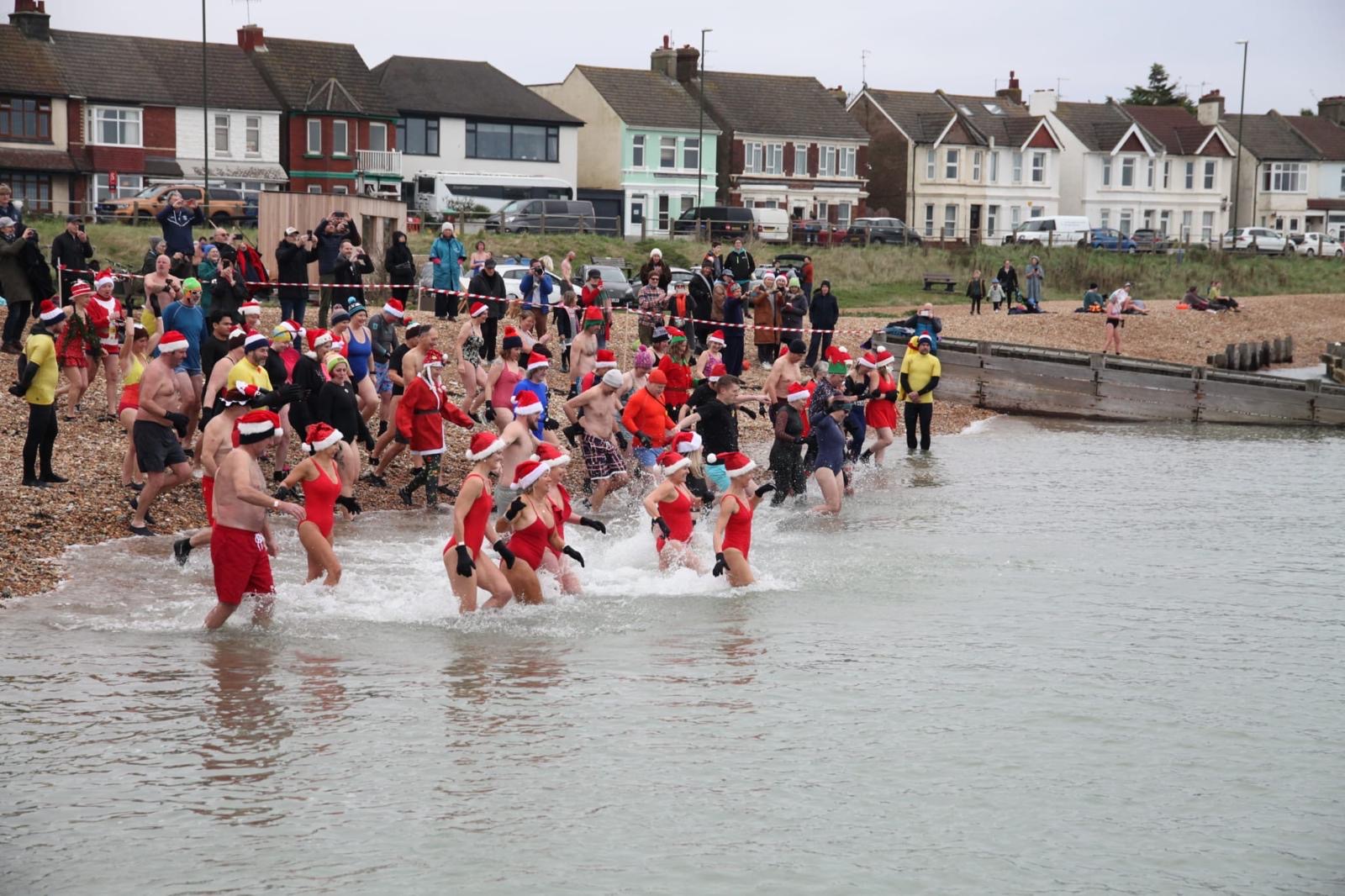 Photo of December Dip participants running into the sea. 