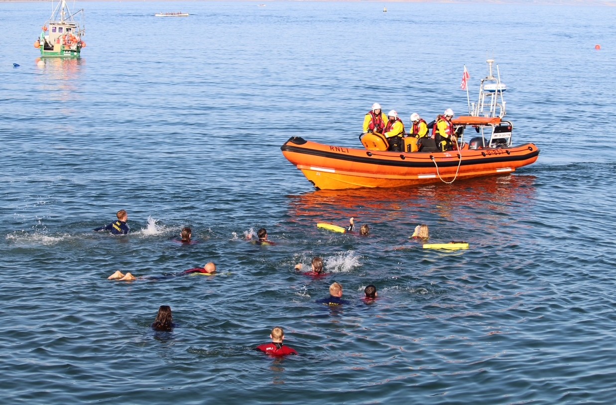 Lifeboat near a group of people floating in the water