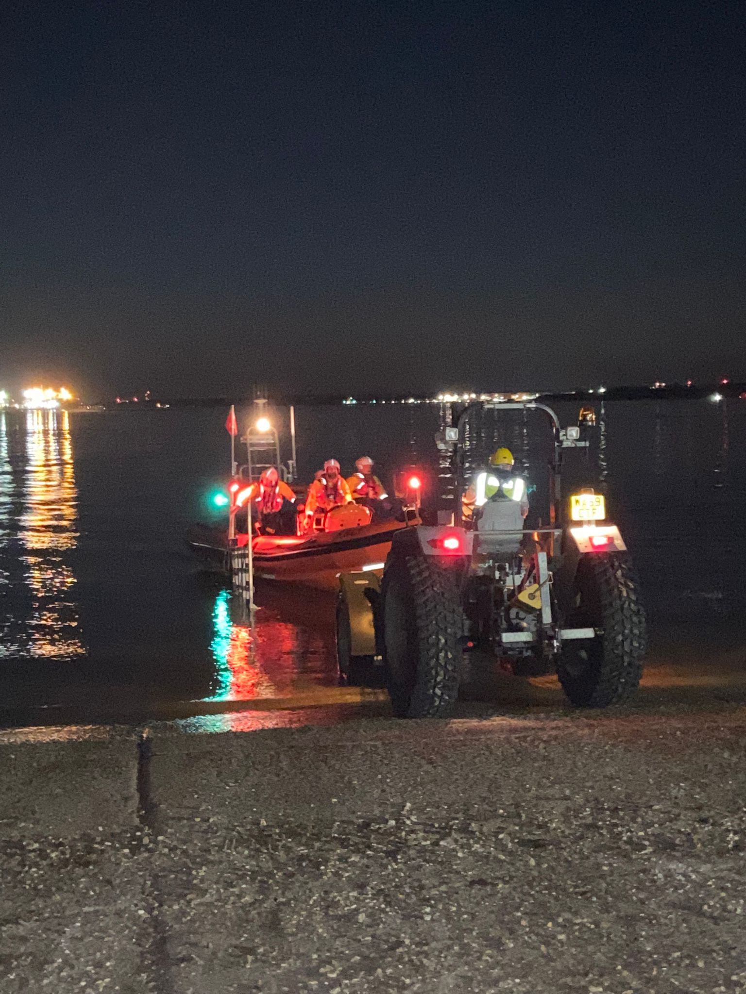 a picture of an Atlantic 85 B Class lifeboat being recovered from the water by a tractor and trailer unit in darkness