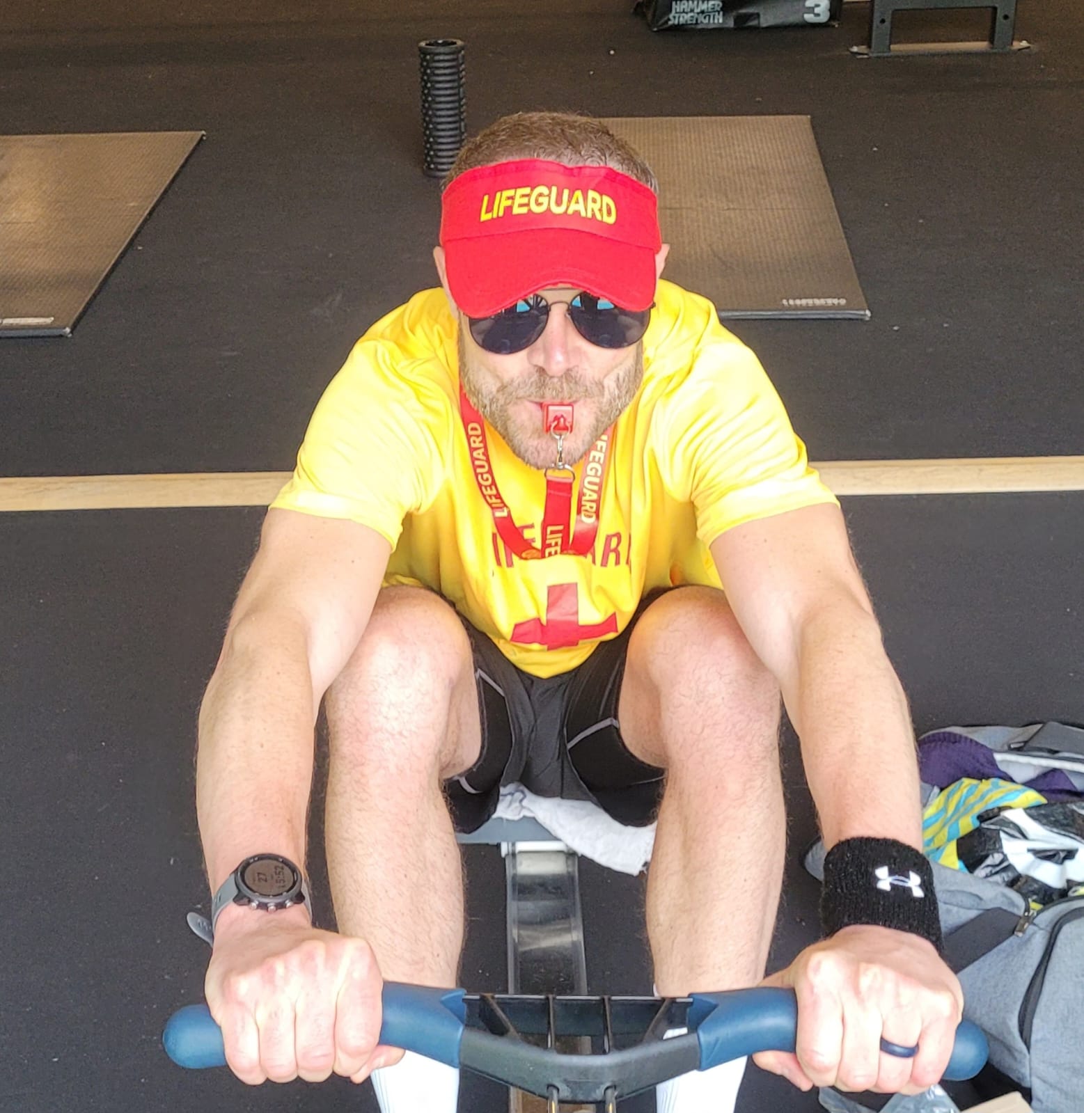 Ground control employee in lifeguard uniform rowing to raise funds