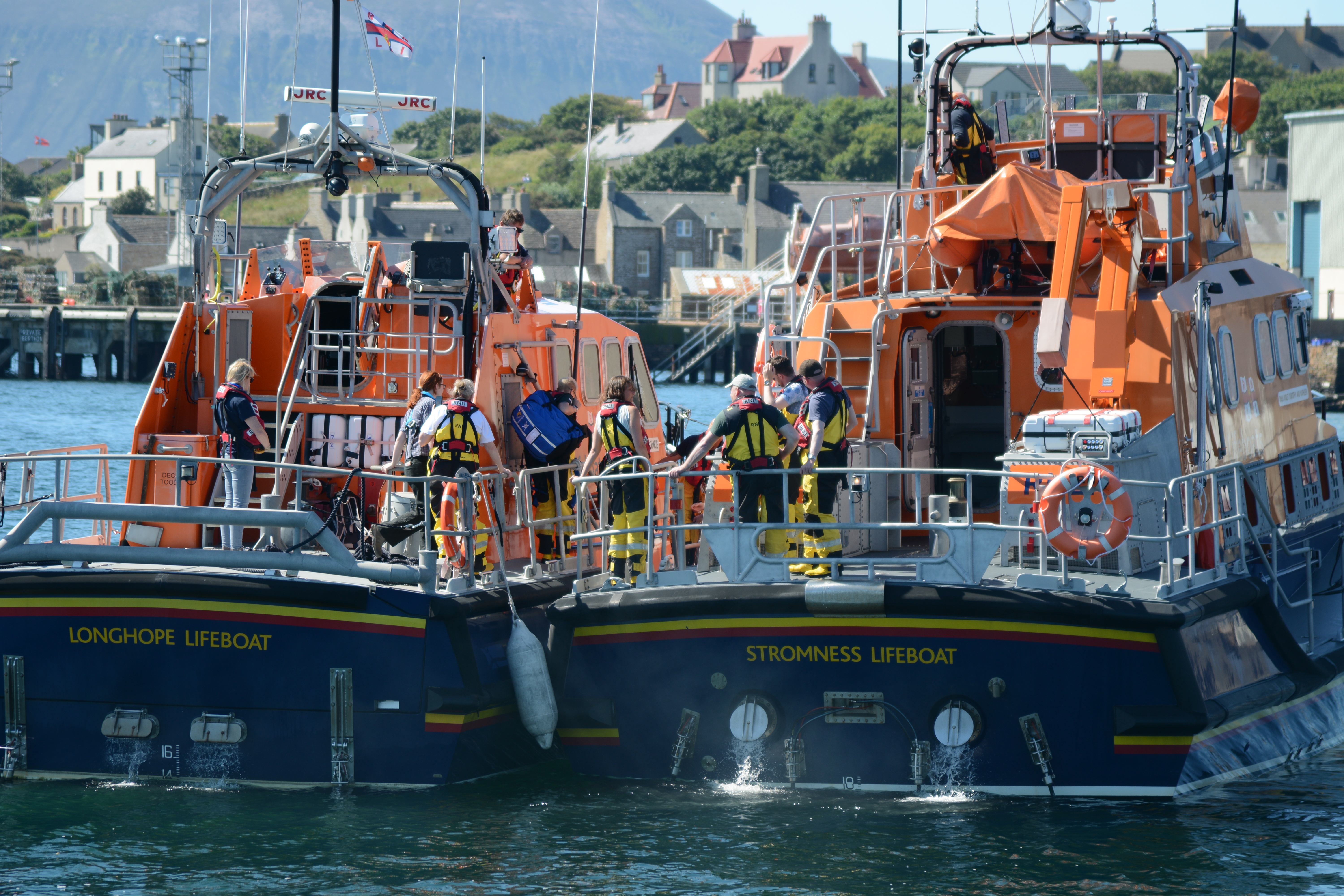 The (blue) sandpiper bag is transferred between lifeboats