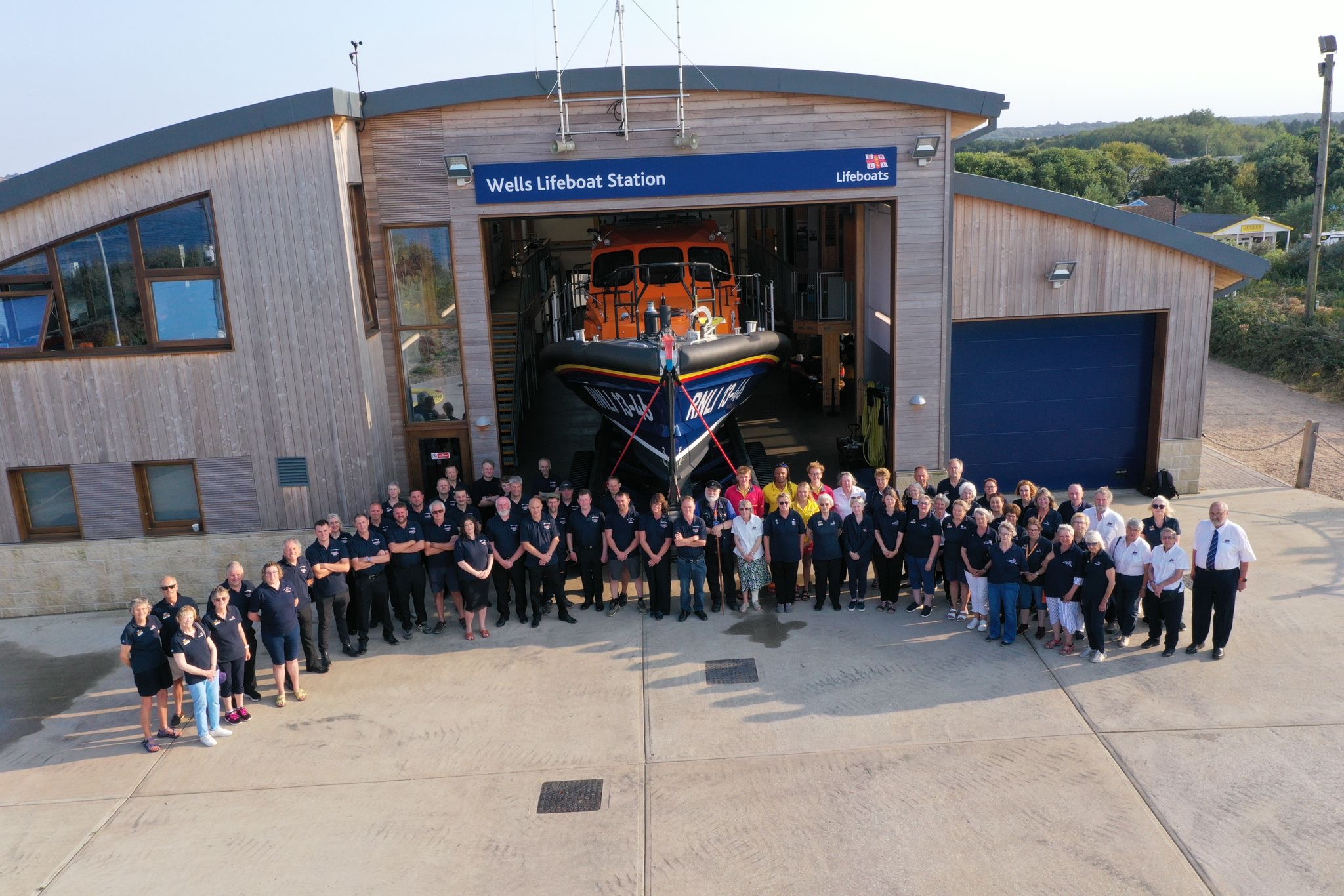 Wells RNLI volunteers in front of lifeboat and station