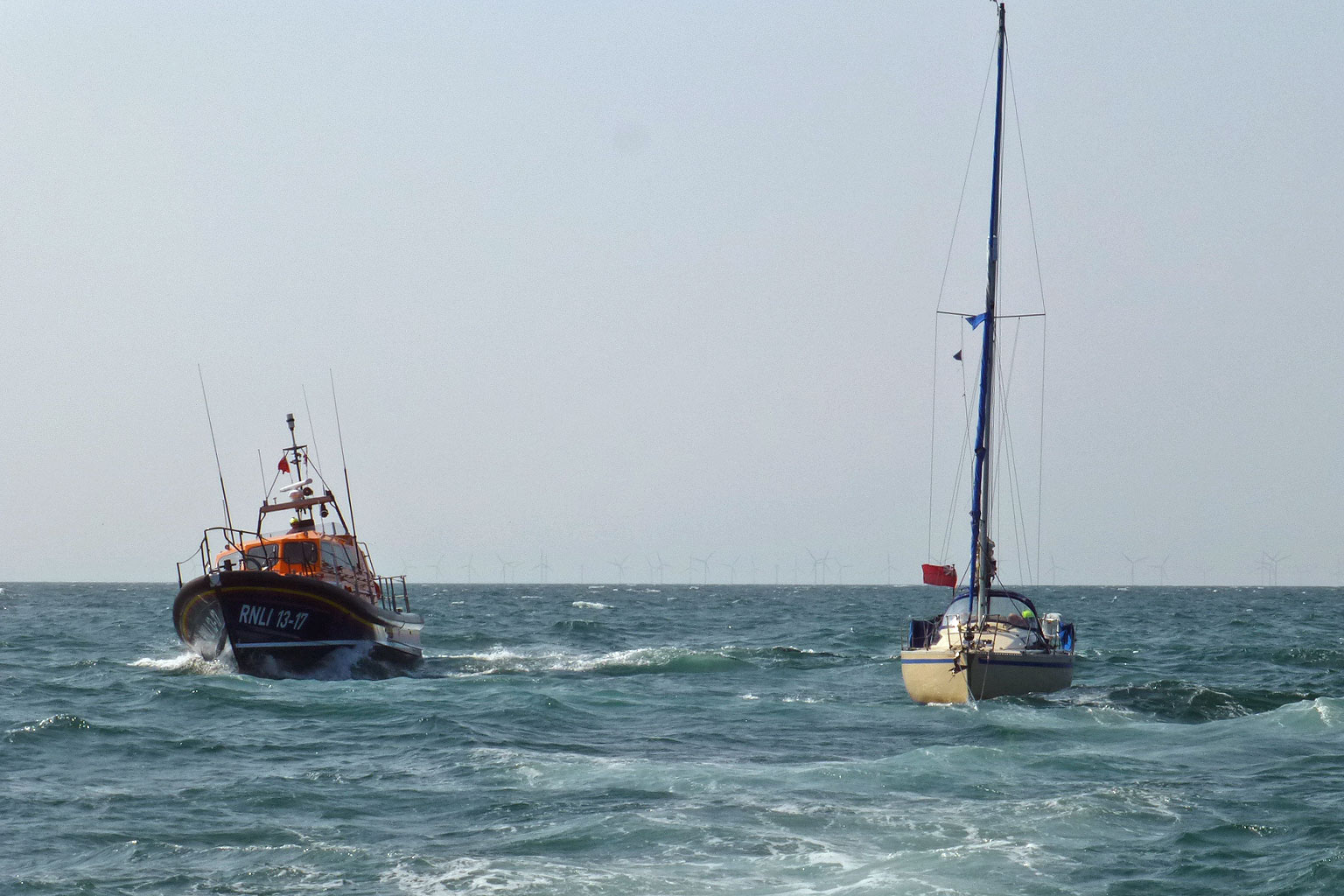 Skegness Shannon class lifeboat and yacht feeling fantastic on open water yacht under tow by Wells RNLI blue skies