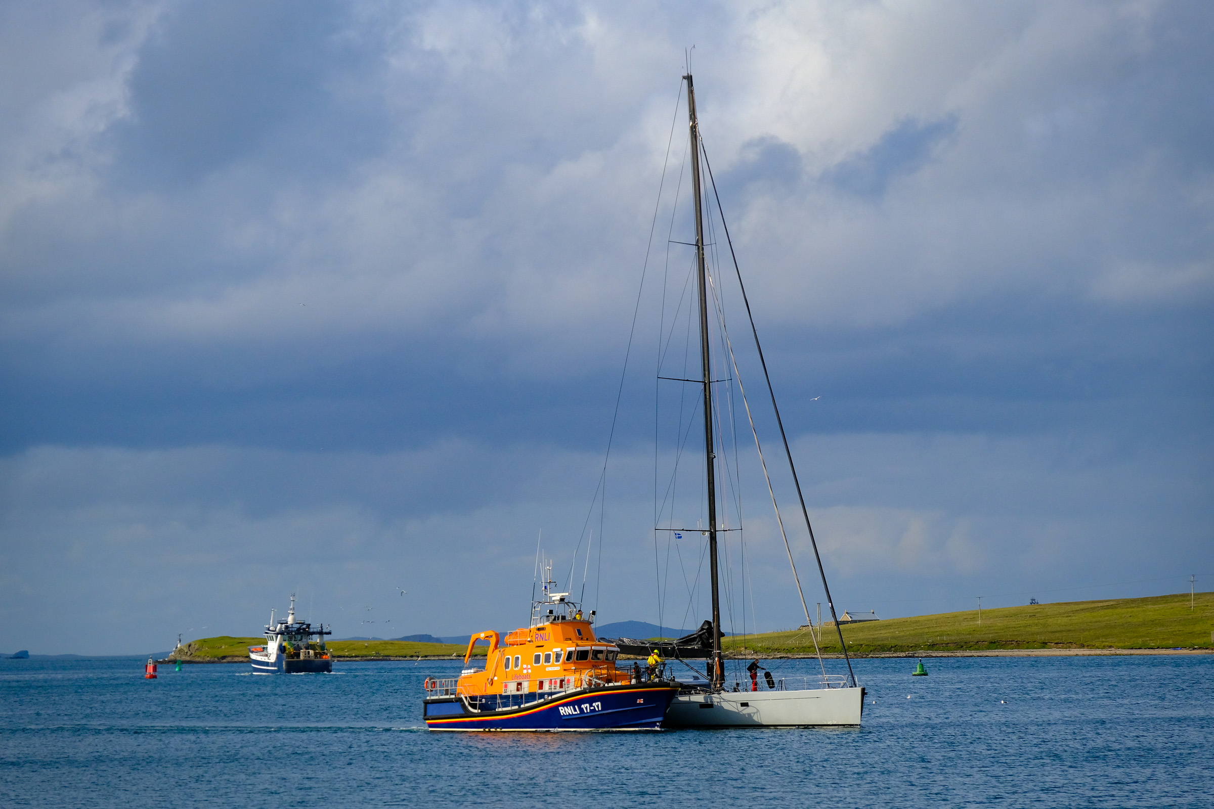 Lerwick lifeboat with a grey hulled yacht alongside, under tow