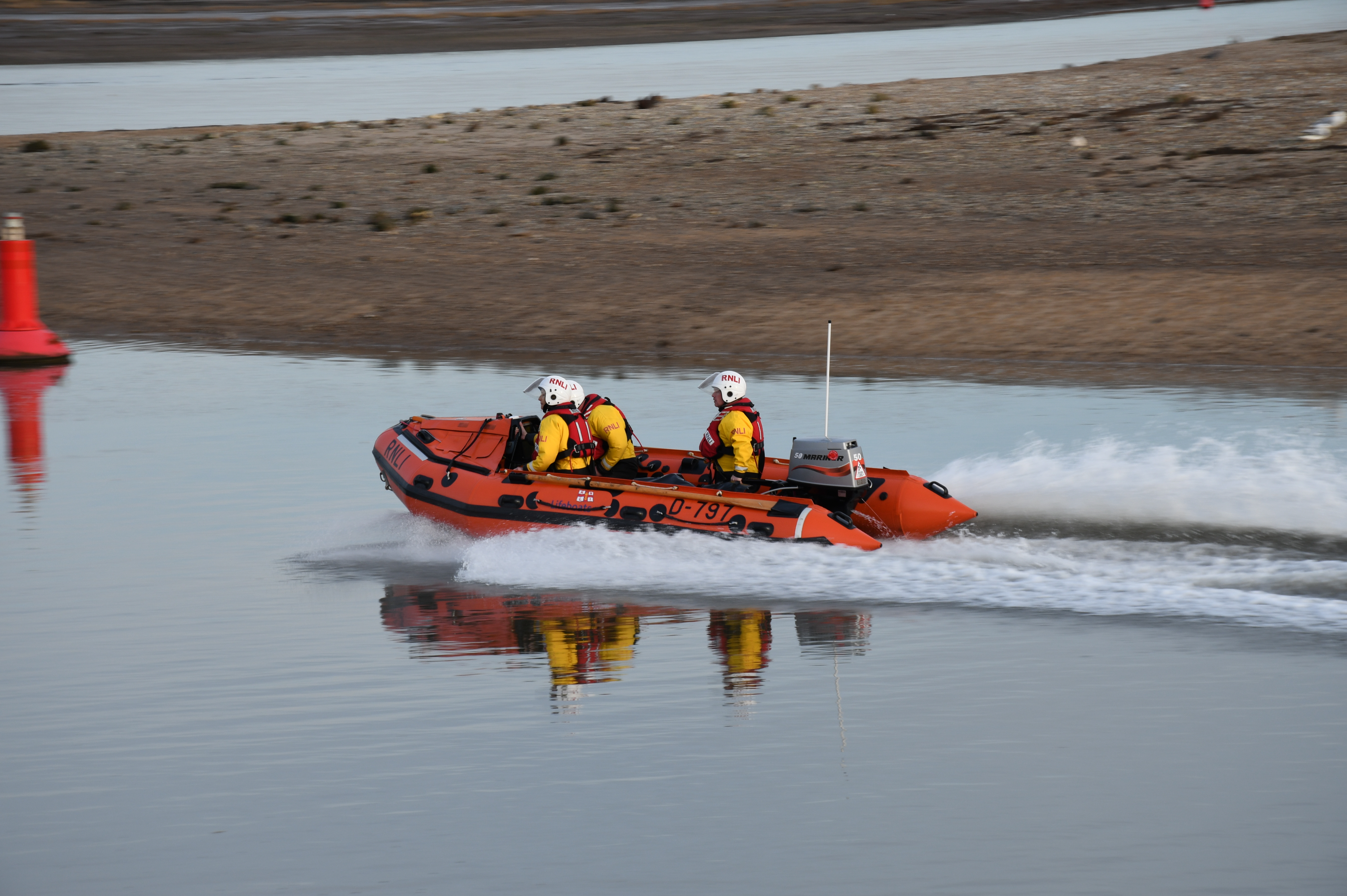 D class lifeboat 'Peter Wilcox' Launches t aid three people cut of by tide three volunteer crew in the lifeboat heading out in harbour channel
