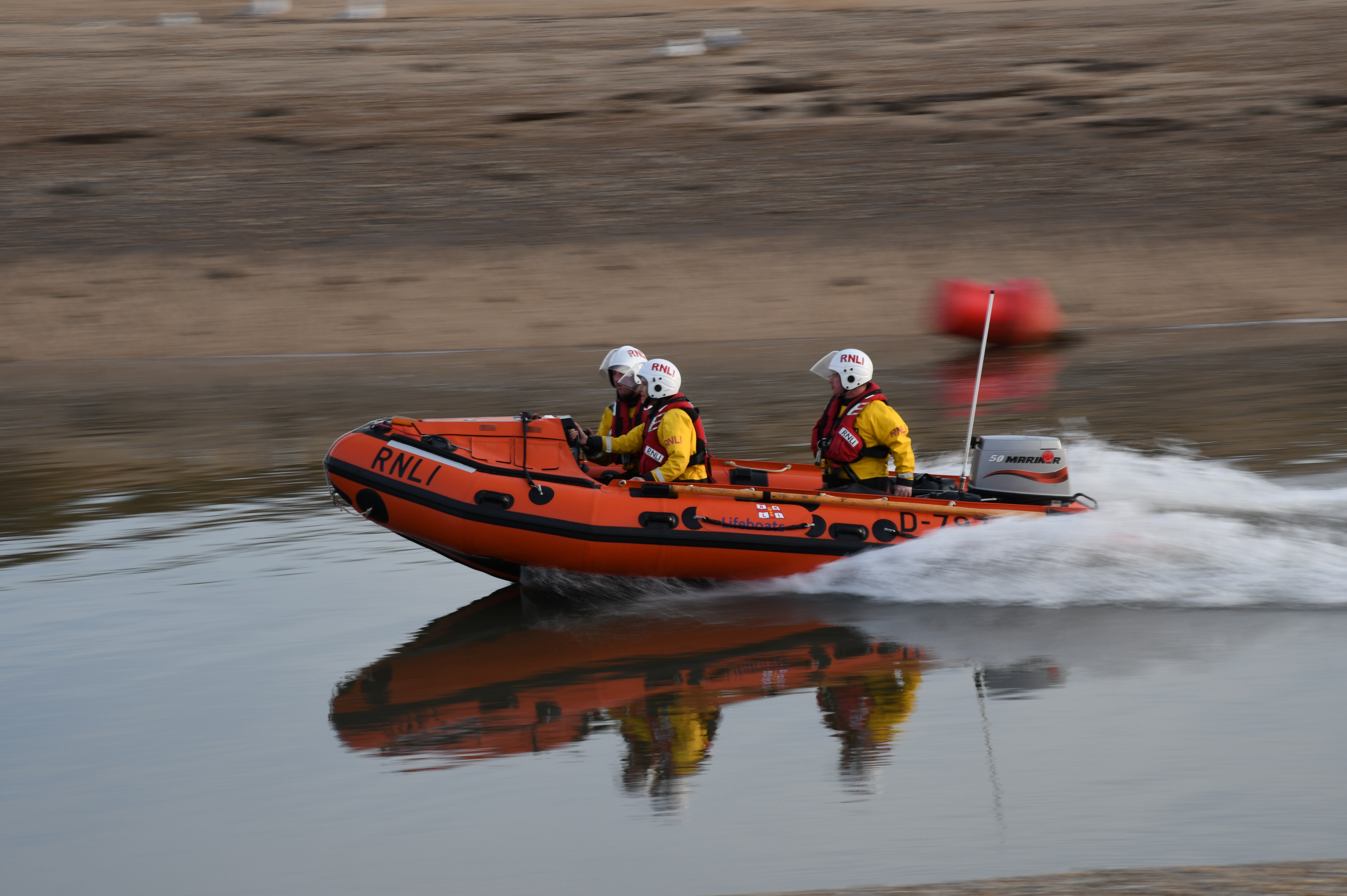 D class lifeboat 'Peter Wilcox' Launches t aid three people cut of by tide three volunteer crew in the lifeboat heading out in harbour channel