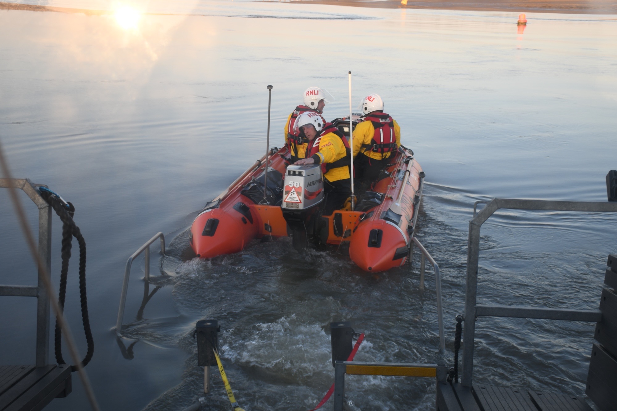 Wells RNLI inshore lifeboat launching with volunteer crew of three 