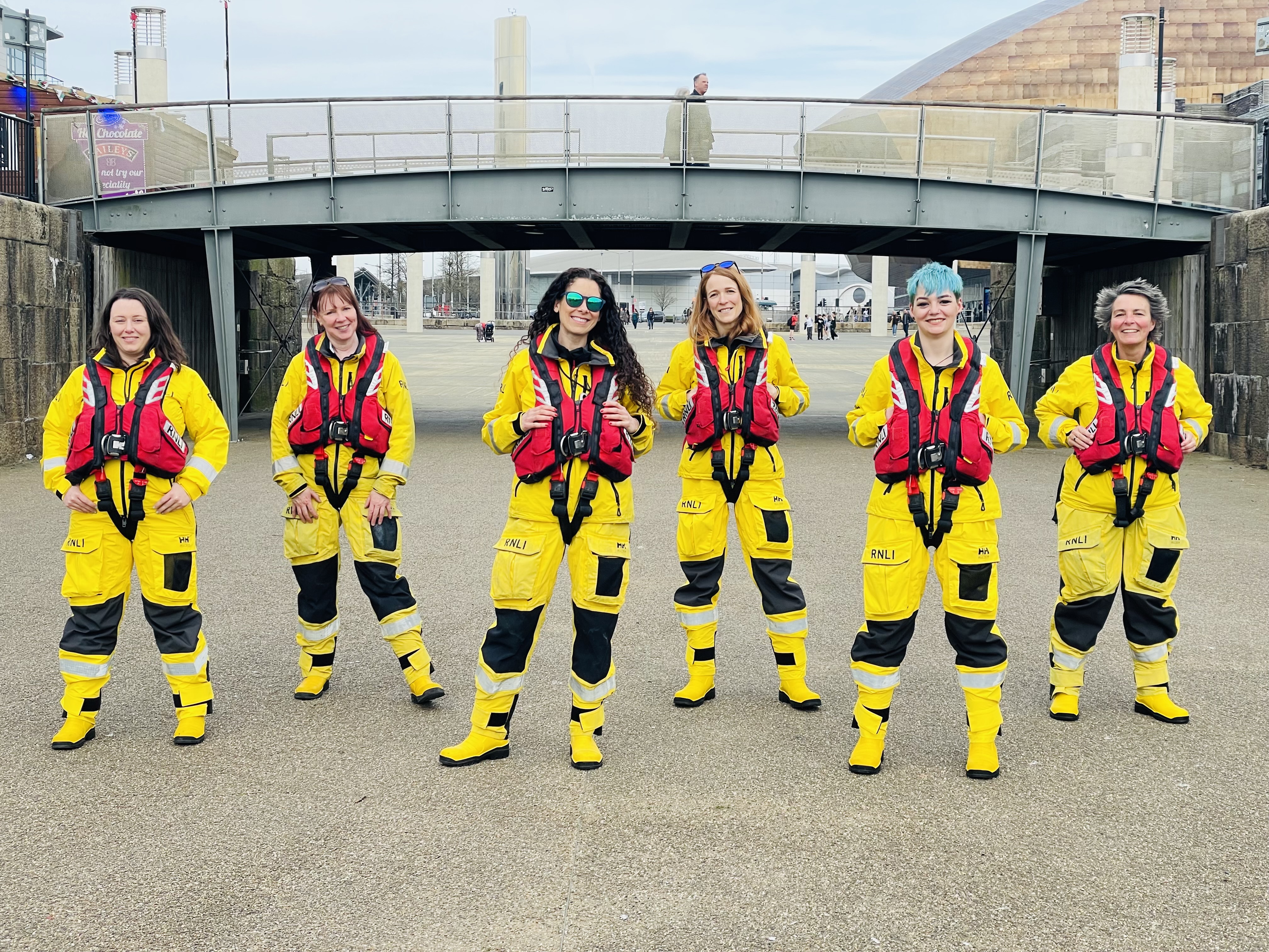 The photo shows 6 volunteers from Barry Dock and Penarth in their kit at Mermaid Quay celebrating International Women's Day