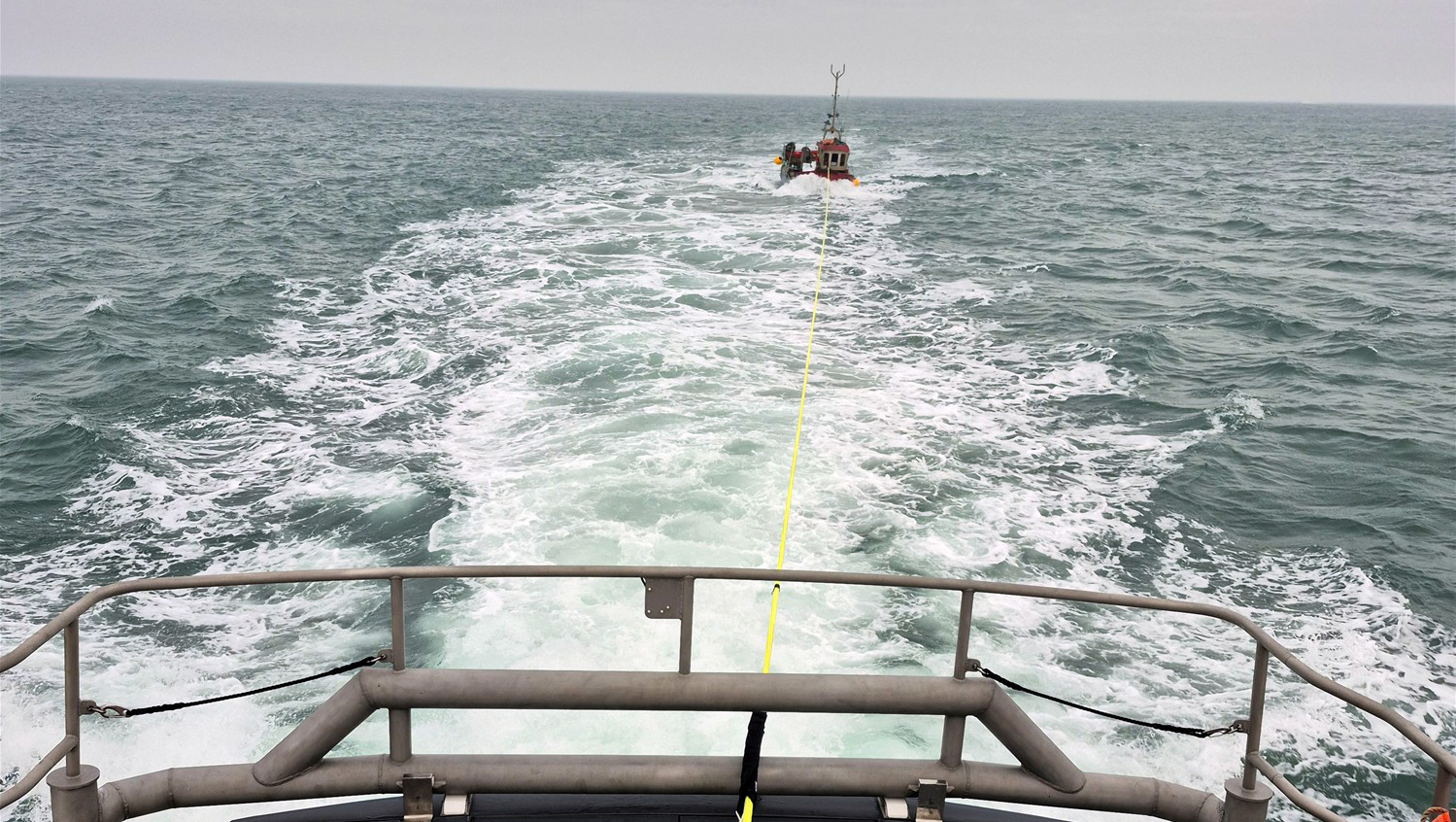 tow line from bow of the lifeboat to small fishing boat in the distance