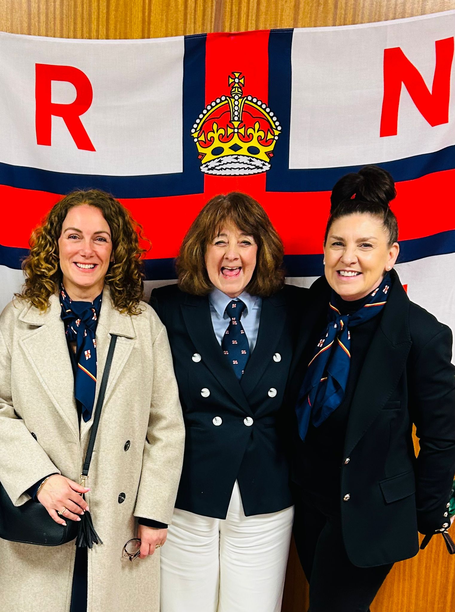 (L-R) RNLI volunteers Sara Sidall - Penarth Fundraising, Avril Kitchen Fundraising Lead Barry Dock and Caroline stood in front of RNLI flag.
