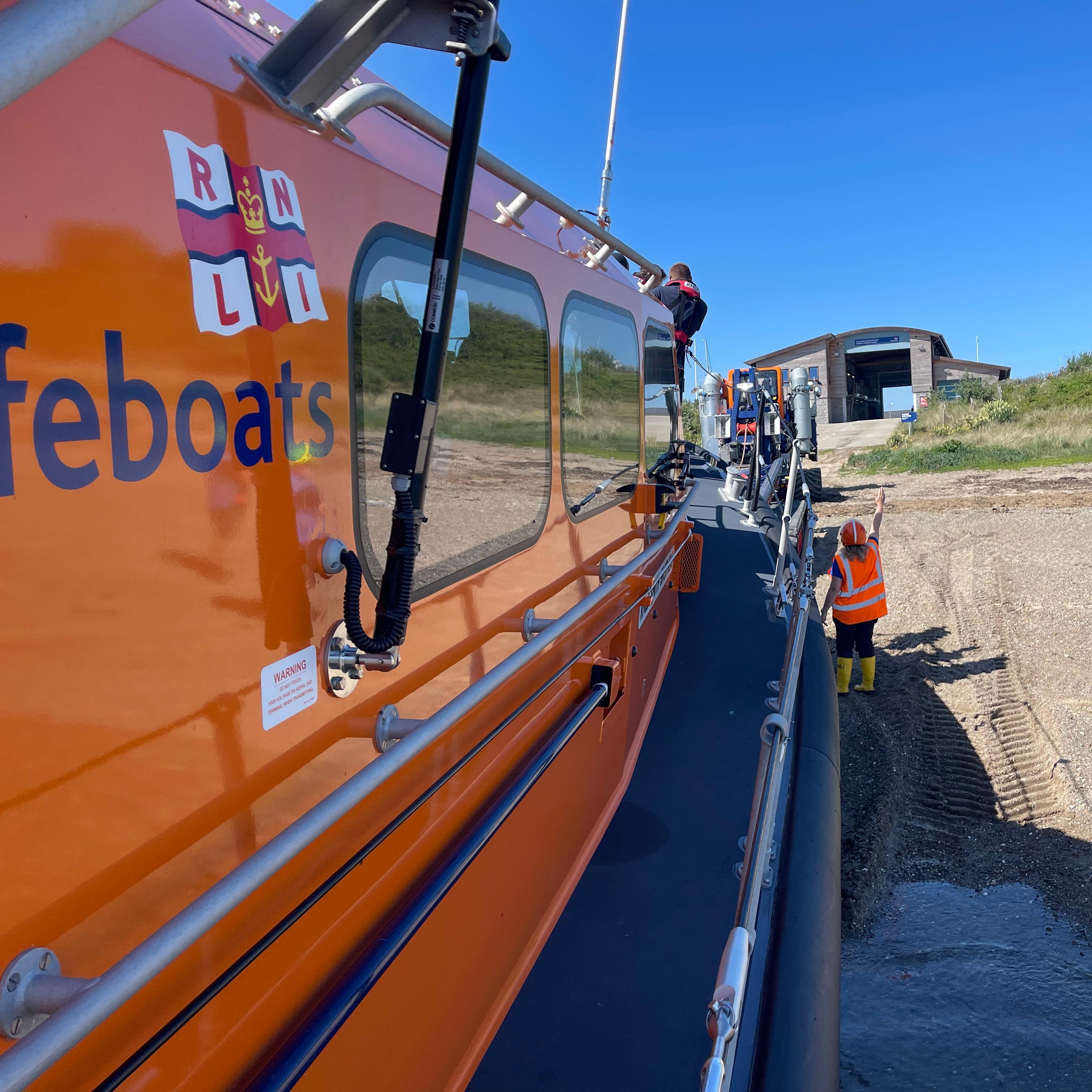 Caroline Jones undertaking Head Launcher duties with arm raised next to Shannon class all-weather lifeboat
