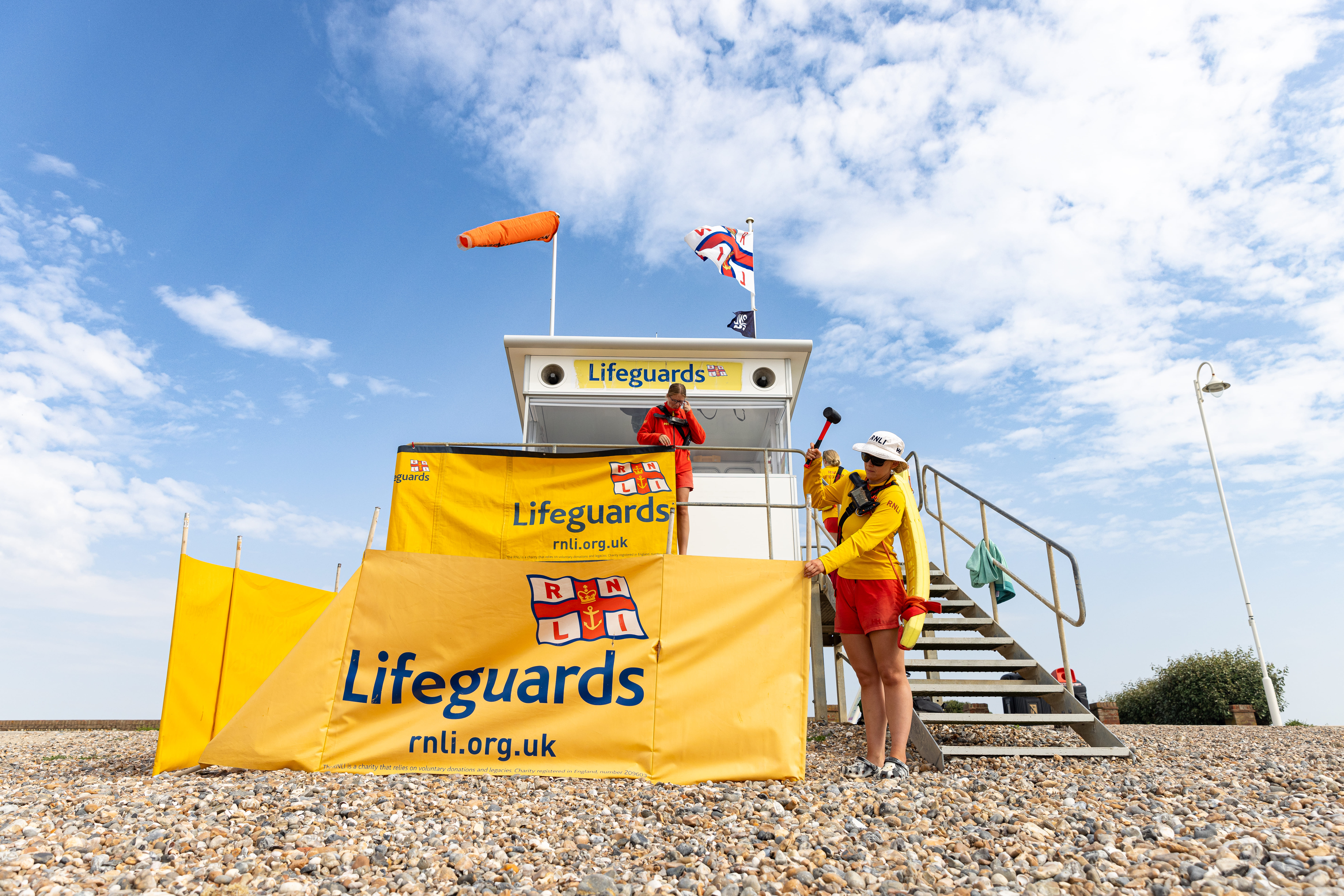 RNLI lifeguards setting up a beach lifeguard unit