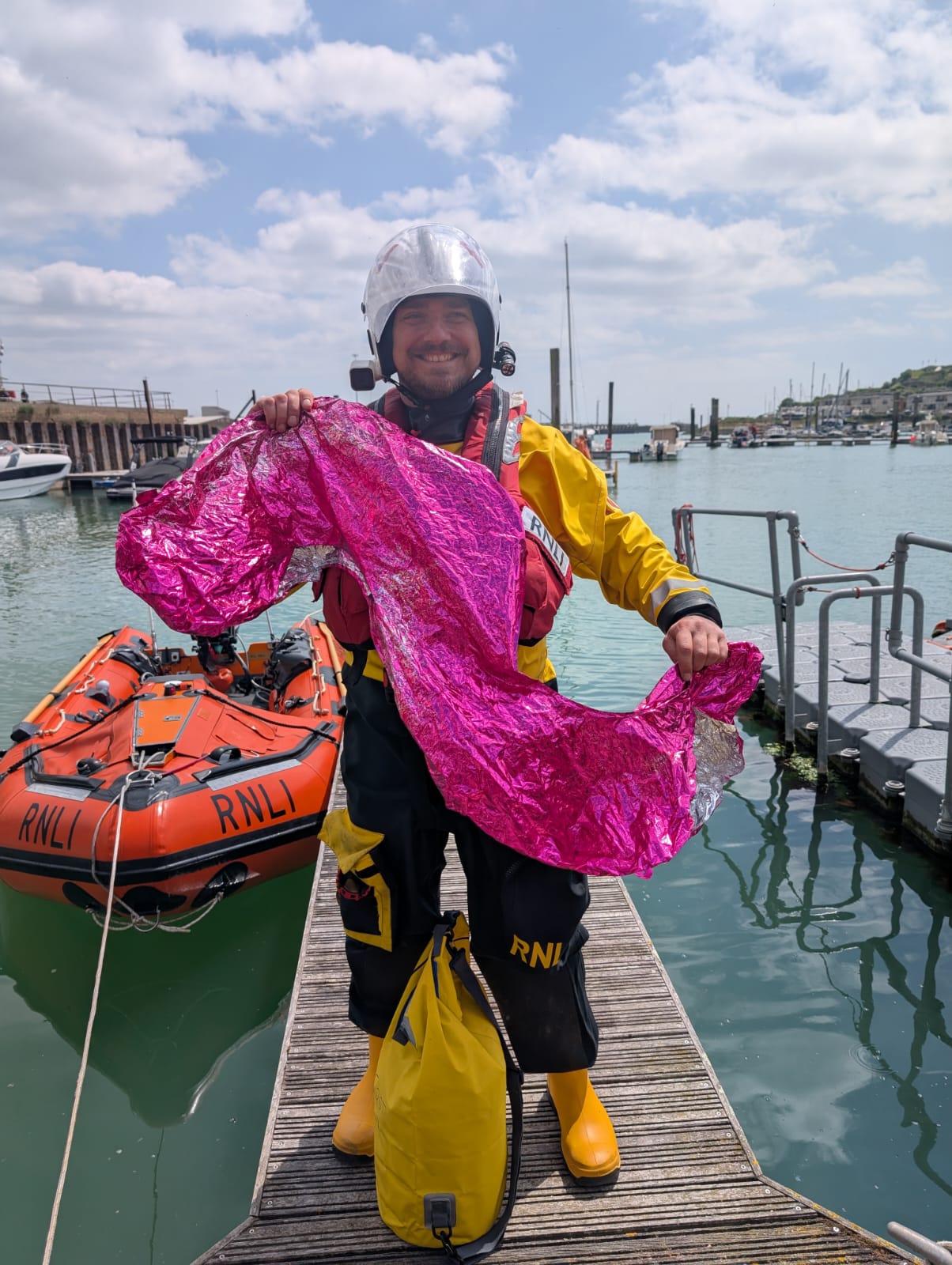 Crew member Will Rowell standing with the rescued red balloon