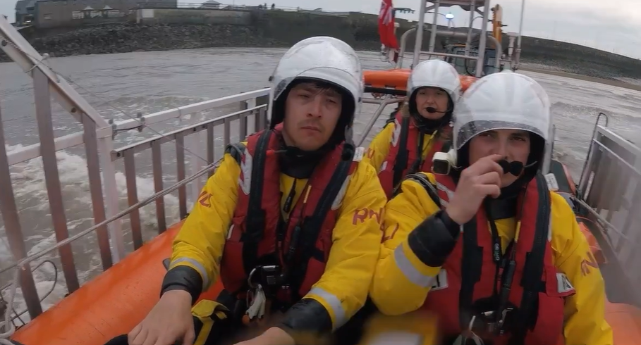 Three crew members sat in the lifeboat about the launch