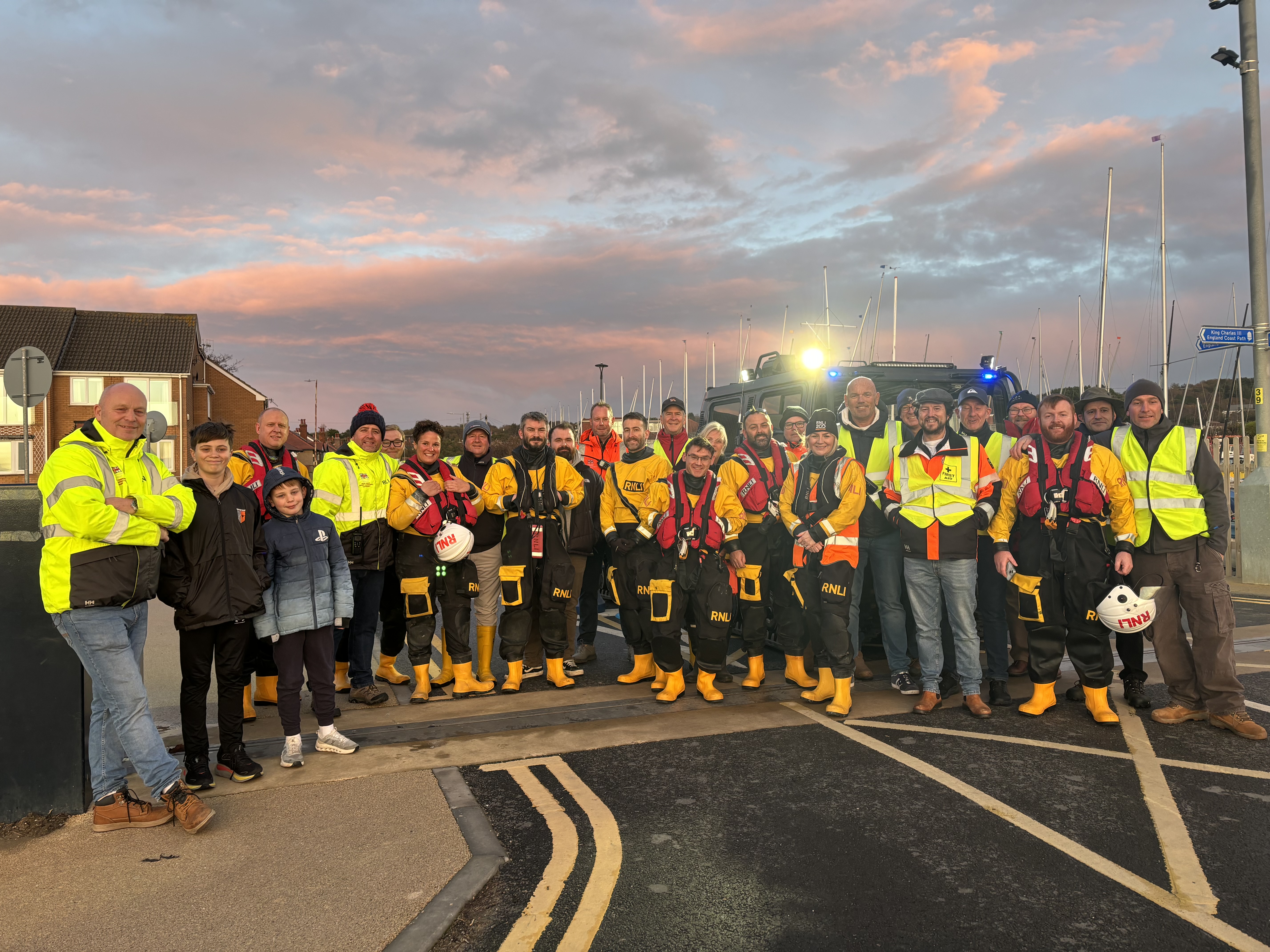 The crew and members of the club can be seen stood in front of the BV and lifeboat.