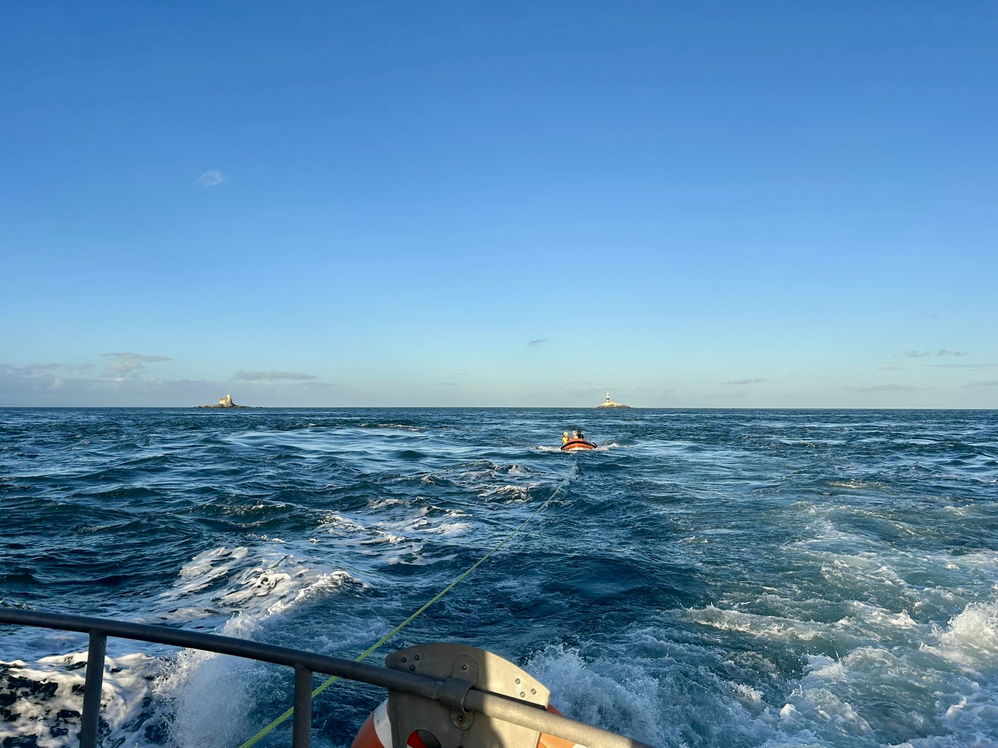 Looking from the back of Larne’s all-weather lifeboat as it tows a small inflatable boat across choppy waters