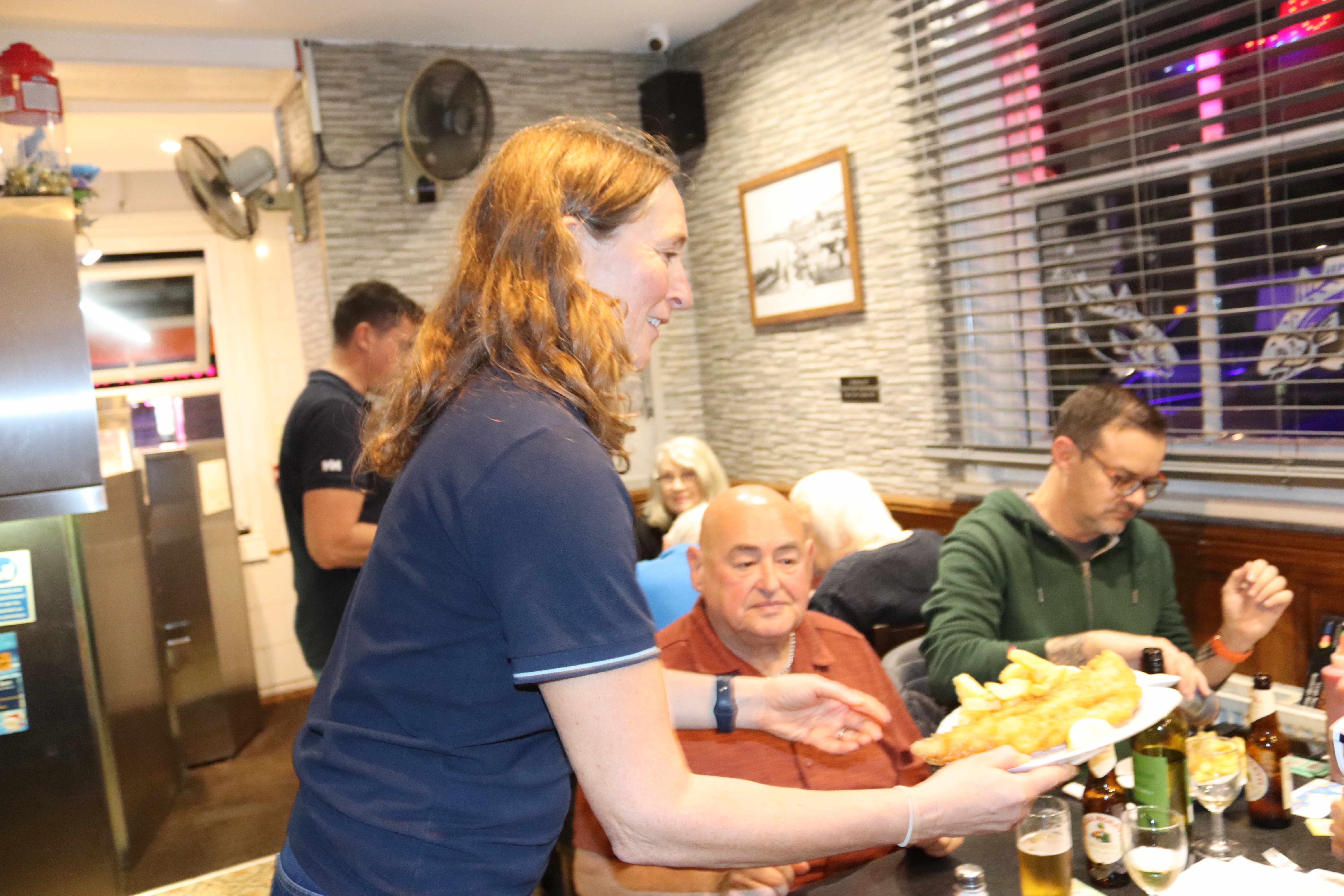 Hastings RNLI crew member Chloe serving customers in the restaurant