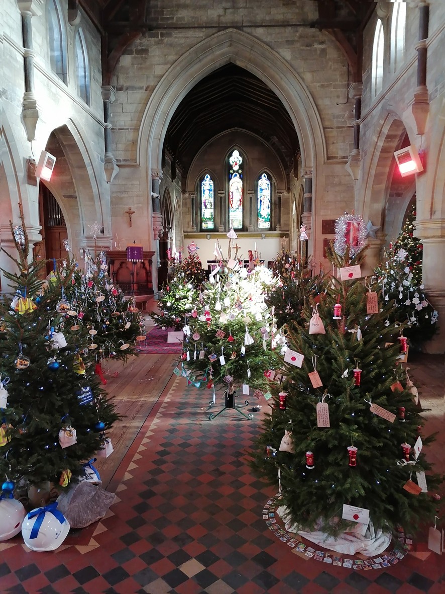 Interior of St George's Church, filled with decorated Christmas trees. 