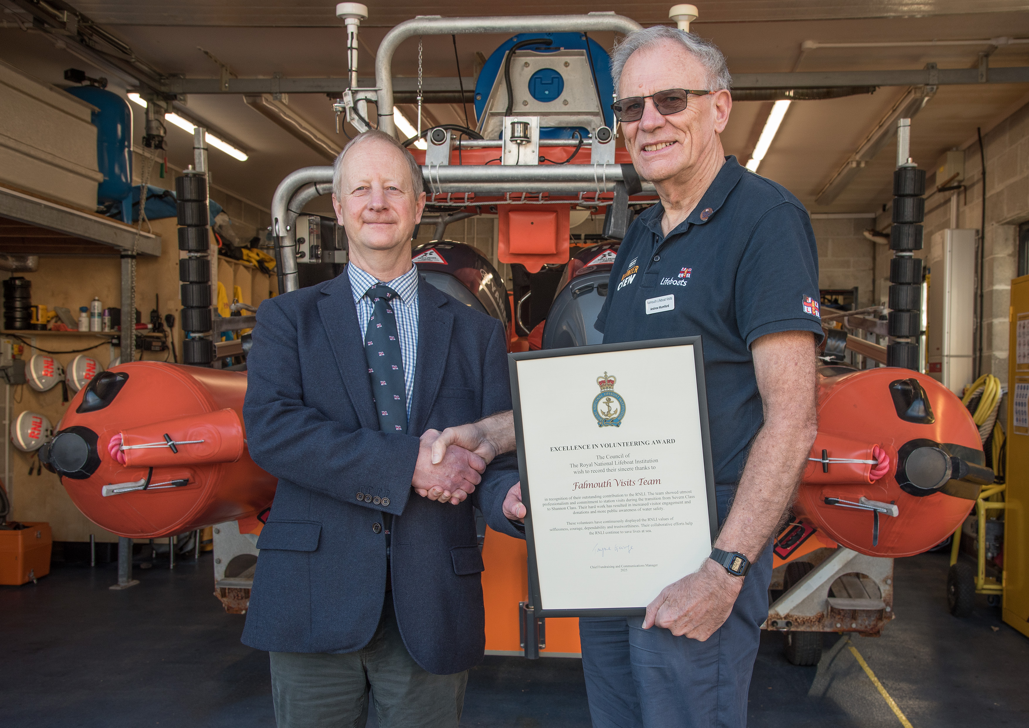 Adrian Carey, RNLI Head of South West Region (left) presenting Falmouth RNLI Visits Officer Andrew Mumford with the award.
