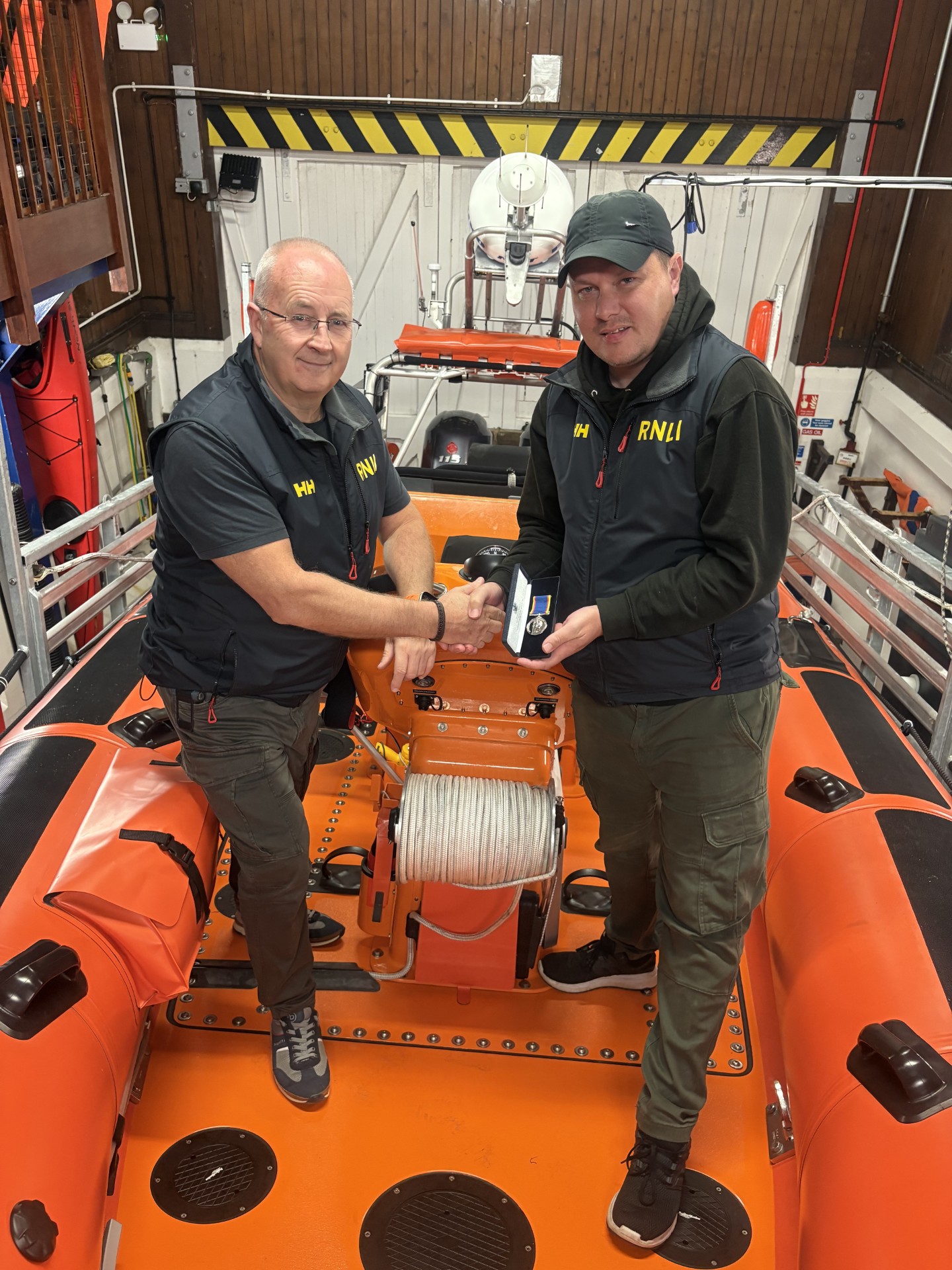 Life Boat Operations manager Kevin Knox presenting Helmsman Michael Percy with his RNLI 20 years long service medal.