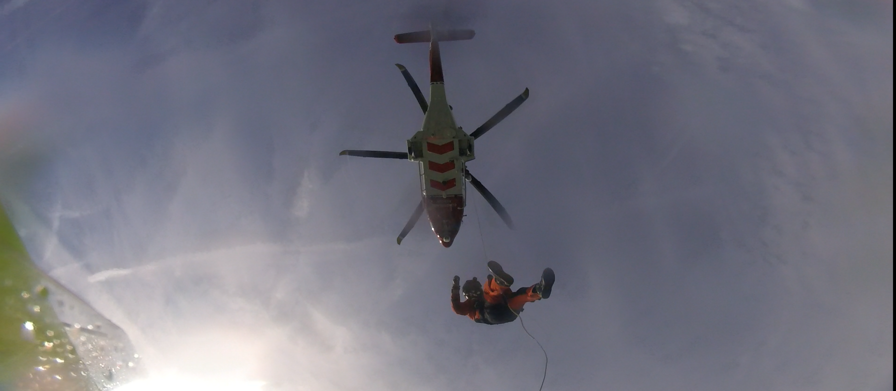 Coastguard winchman lowered to lifeboat.