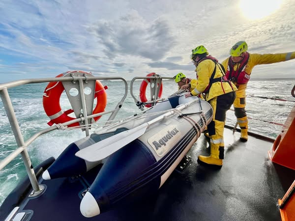 RNLI Volunteer Crew Ollie Whelan&amp; David Butterell recovered tender on aft deck.