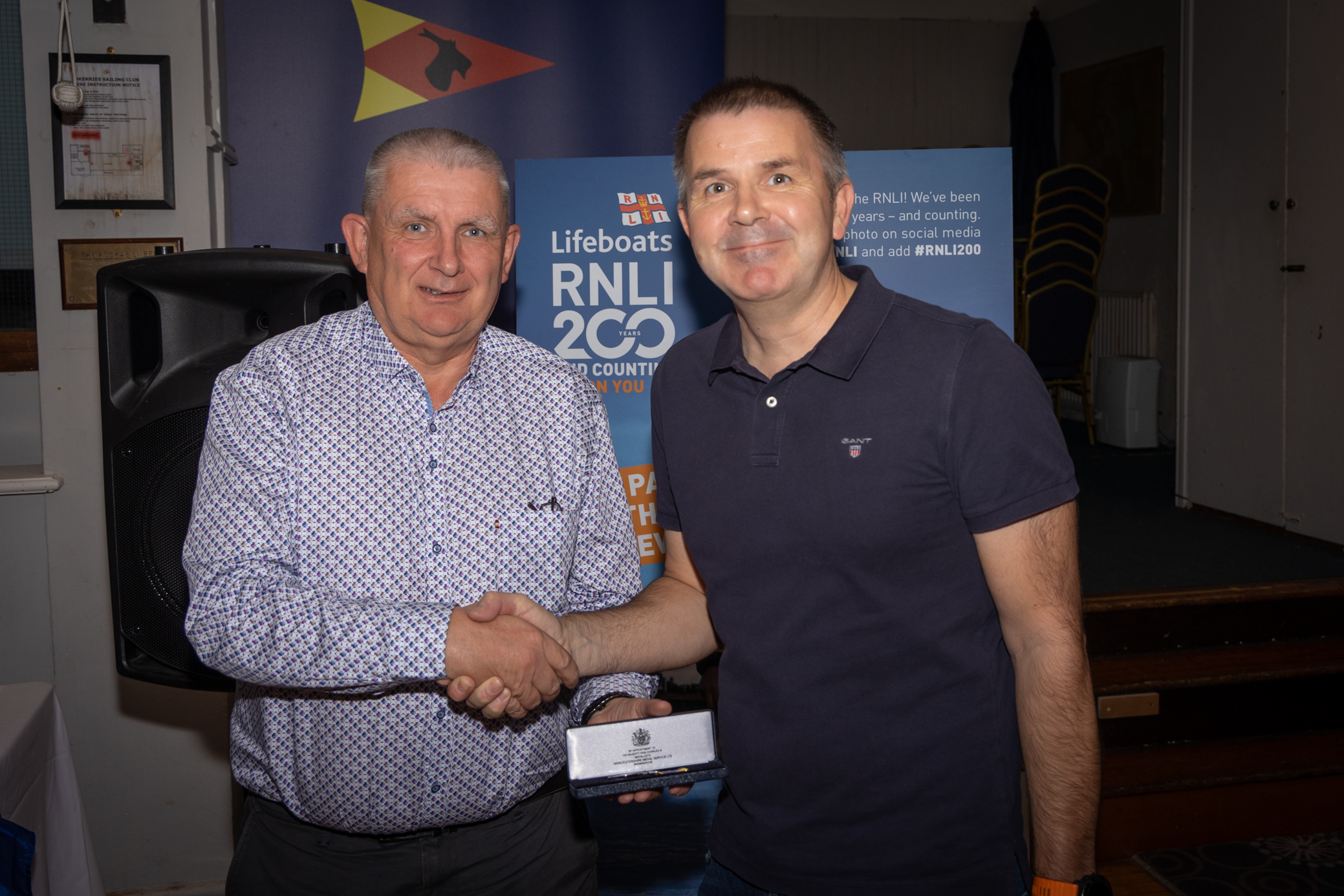 Incoming Lifeboat operations manager Peter Duff presenting Rob Morgan with his long service medal.