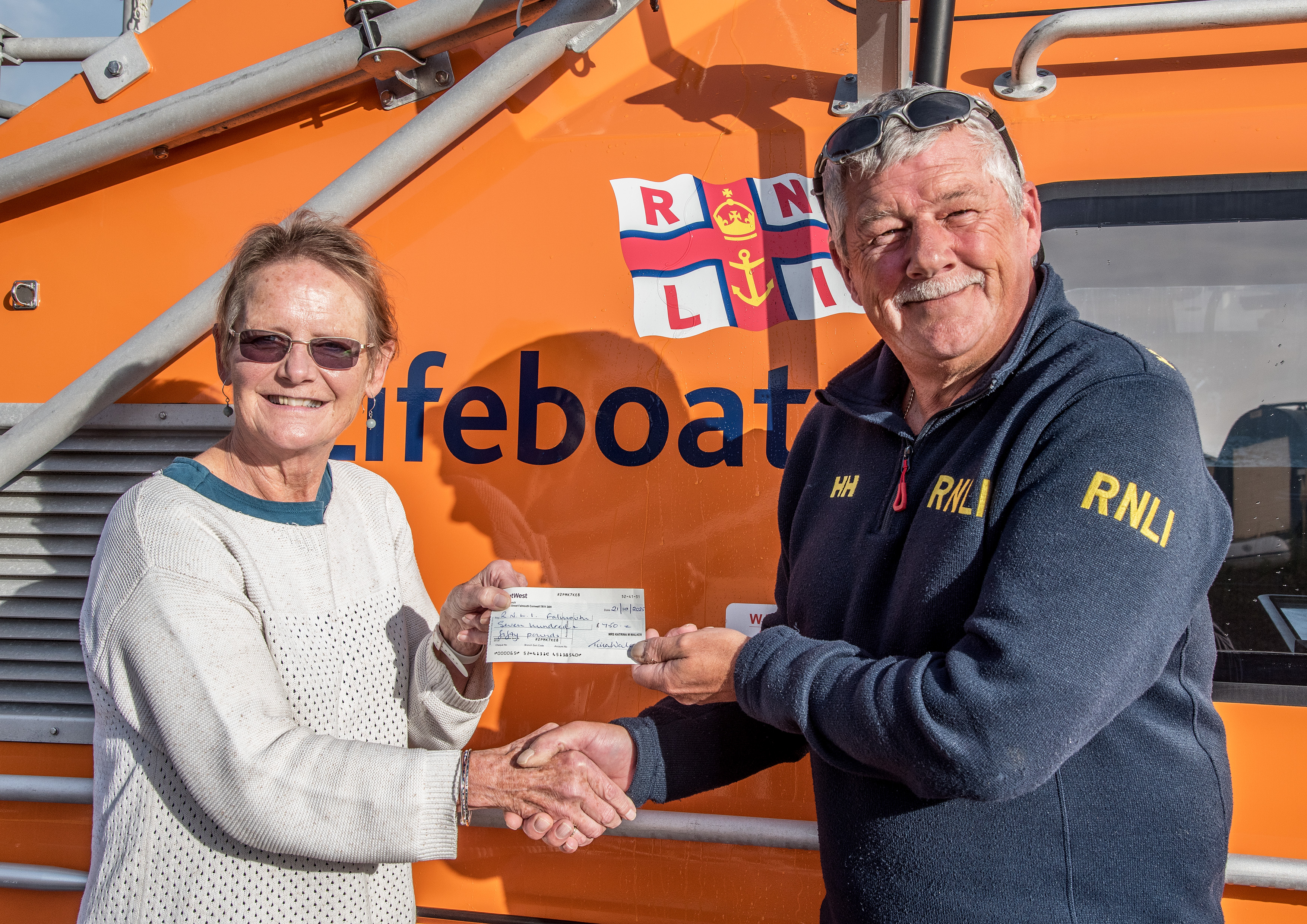 Tina Walker presenting the cheque to Senior Station Technician Jon Blakeston on board the Shannon class all-weather lifeboat Decibel Too