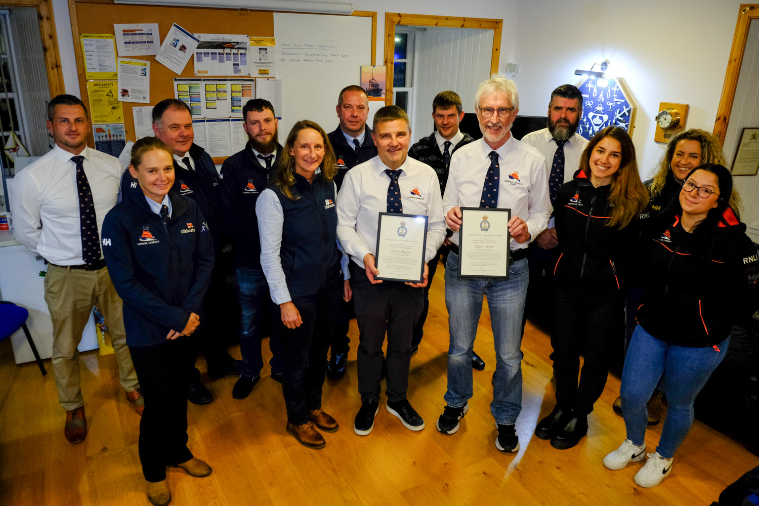 Jill Hepburn (fifth from left) presented 'Excellence in Volunteering' Awards to John Angus and Peter Kerr at Lerwick Lifeboat Station last night, in the company of most of the lifeboat crew.