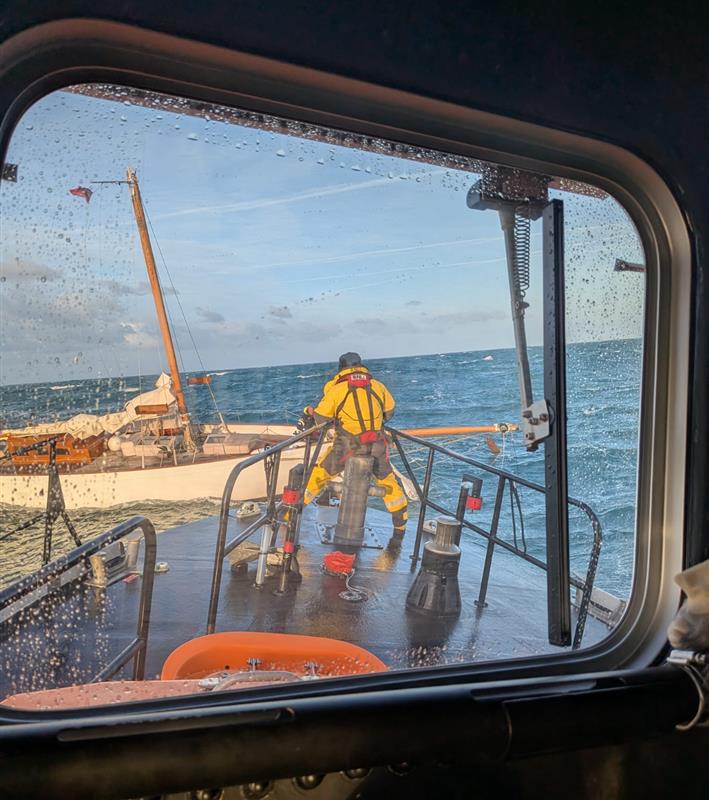 Yarmouth Lifeboat at sea in rough swells attending to a vessel with a snapped mast.