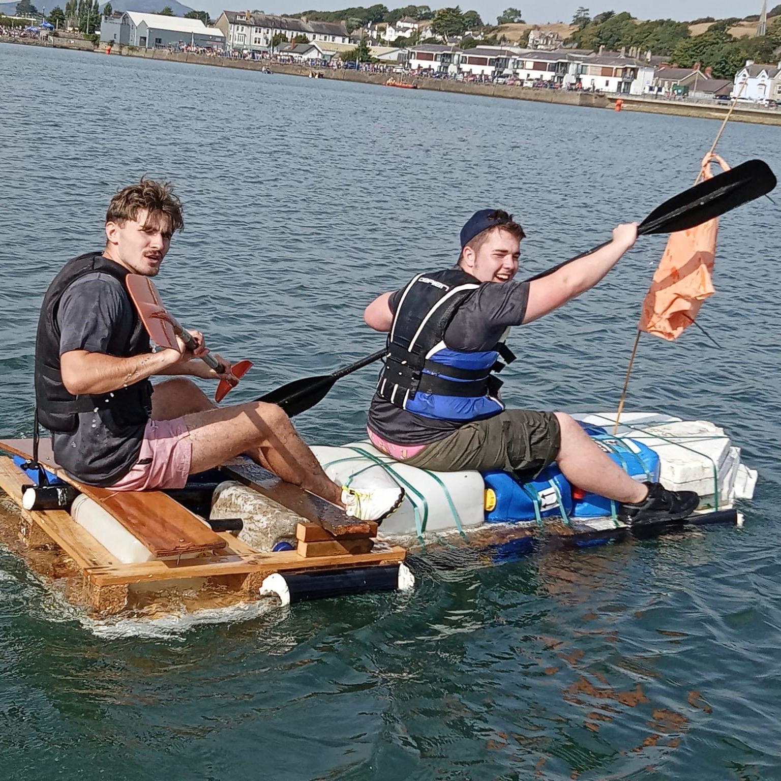 Charity Raft Race entrants having fun on the water on a home build raft