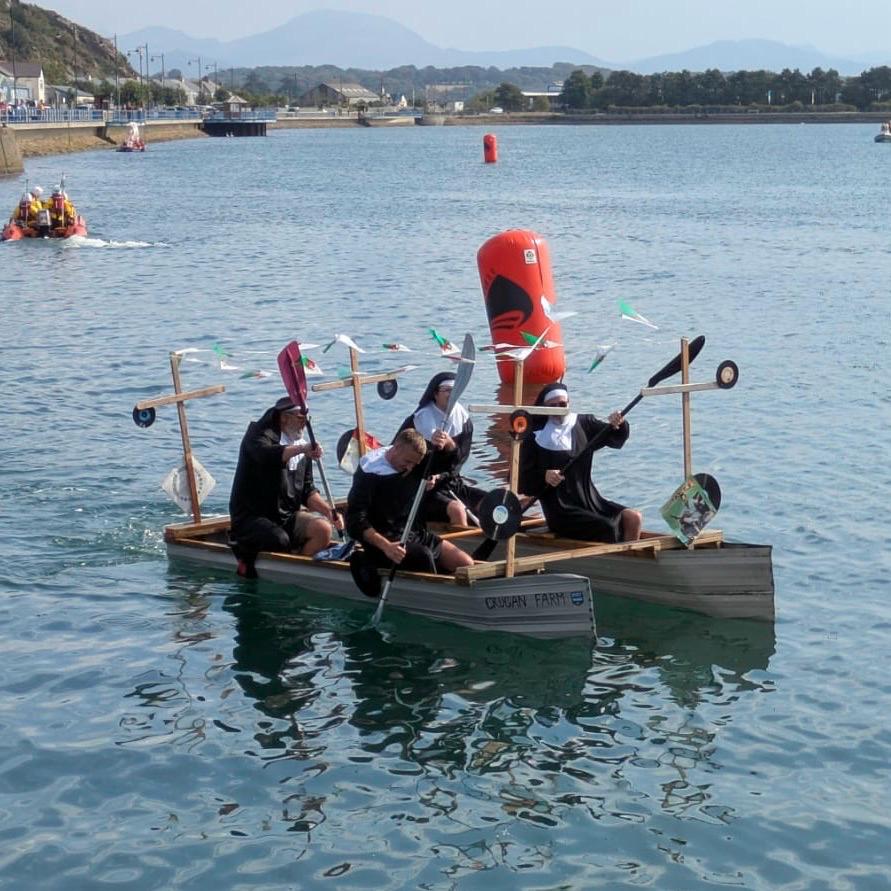 Charity Raft Race entrants having fun on the water on a home build raft